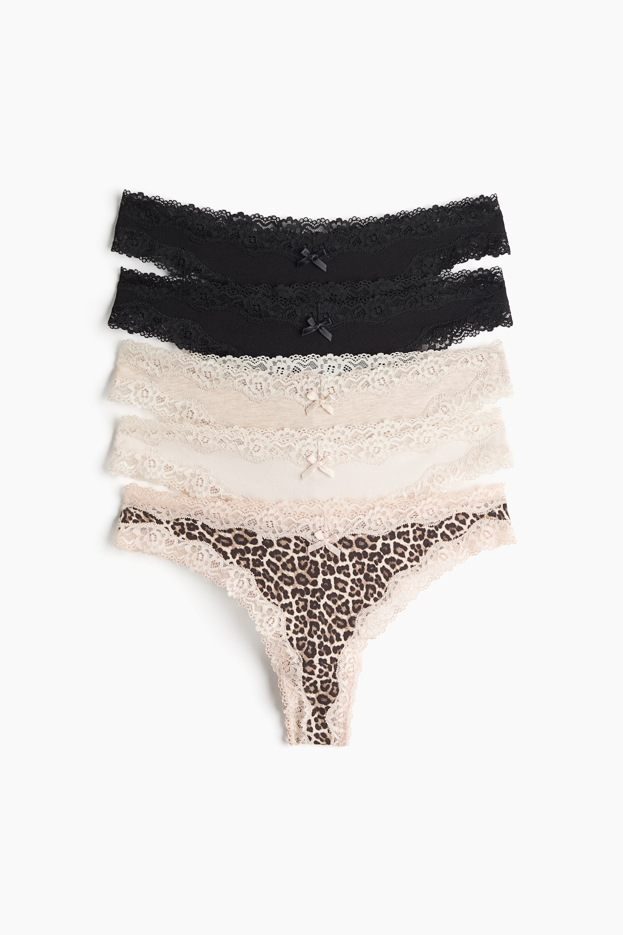 View larger image: A five-pack of cotton jersey and lace briefs is laid flat, viewed from the front, showcasing a stacked arrangement of different designs. The selection features two solid black pairs, one light beige pair, one off-white pair, and one leopard-print pair, each with a V-shaped lace waistband adorned with a small bow at the center.