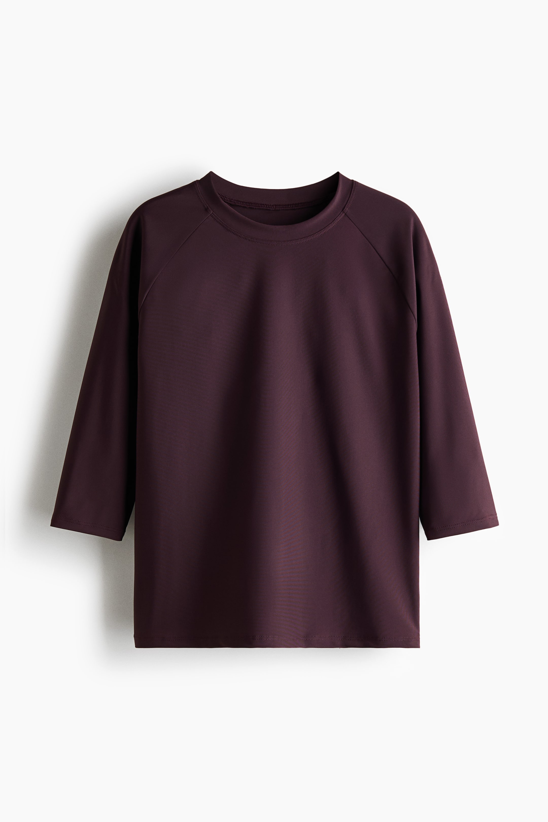 Visualizza l'immagine ingrandita: Un top da nuoto sportivo color bordeaux scuro con protezione UPF 50 è mostrato frontalmente, caratterizzato da uno scollo rotondo, maniche raglan a tre quarti e un tessuto liscio e uniforme.