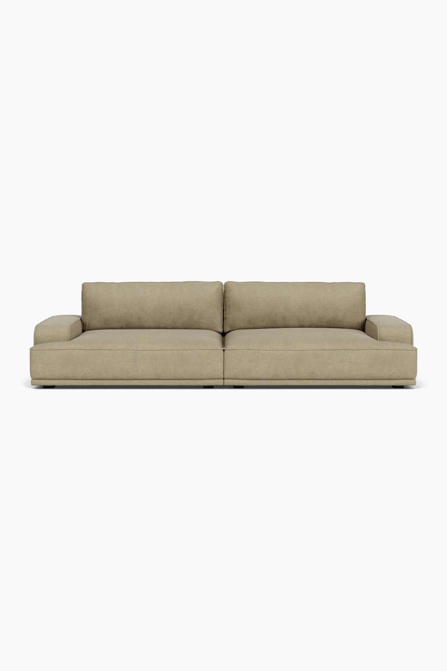 Un canapé modulaire bas, revêtu dâun tissu texturé de couleur ocre, est orienté vers la droite, mettant en valeur son coussin dâassise profond, son dossier bas et son large accoudoir massif. Un coussin décoratif carré assorti est appuyé contre le dossier sur le coussin dâassise.