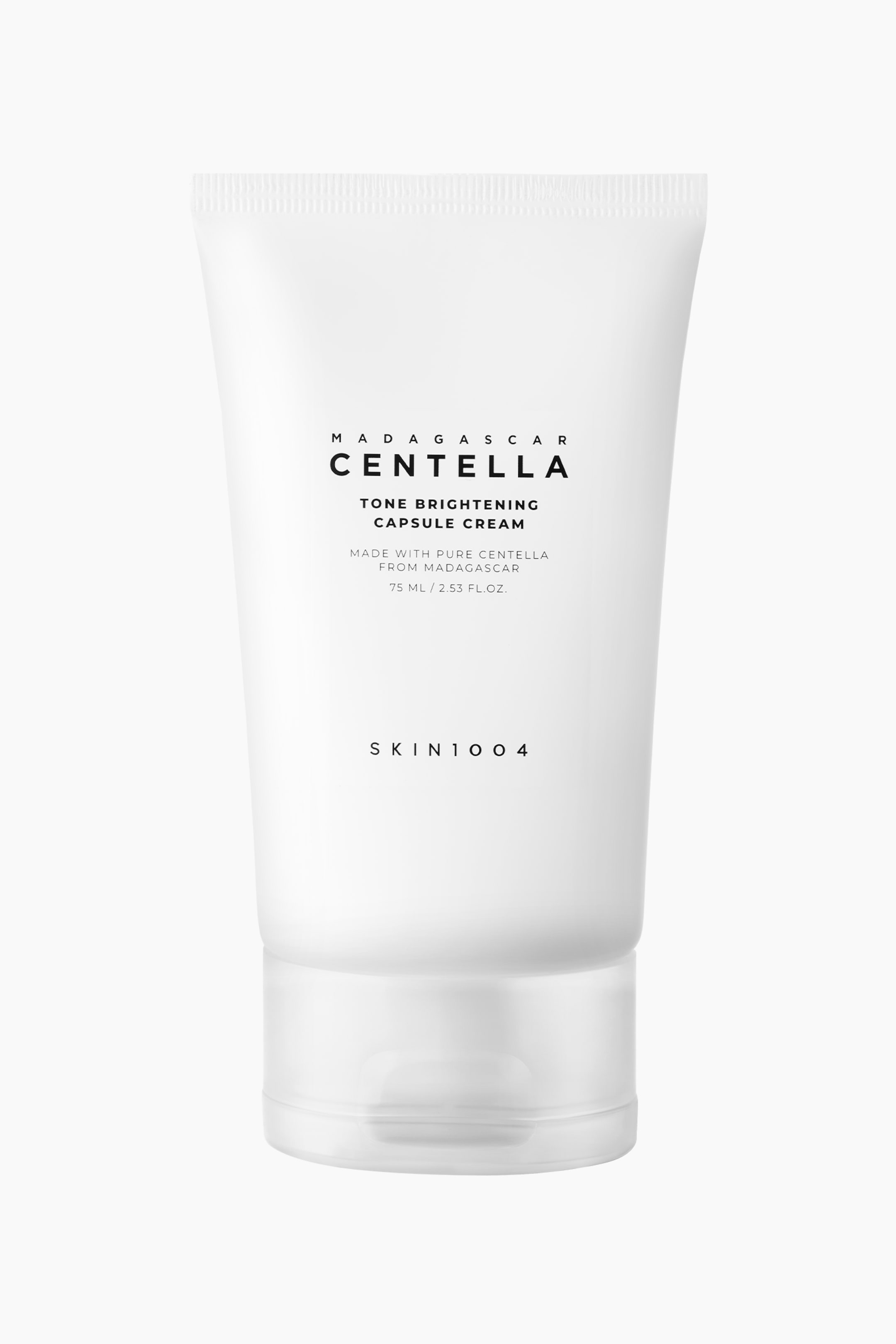 Näytä suurempi kuva: Valkoinen mattapintainen puristettava tuubi Madagascar Centella Tone Brightening Capsule Cream -voidetta seisoo pystyasennossa ja osoittaa eteenpäin, ja siinä on läpikuultava flip-top-korkki. Tuubissa oleva musta teksti kertoo: 'Madagascar Centella', 'Tone Brightening Capsule Cream', '75 ML / 2.53 FL.OZ.' ja 'SKIN1004'.