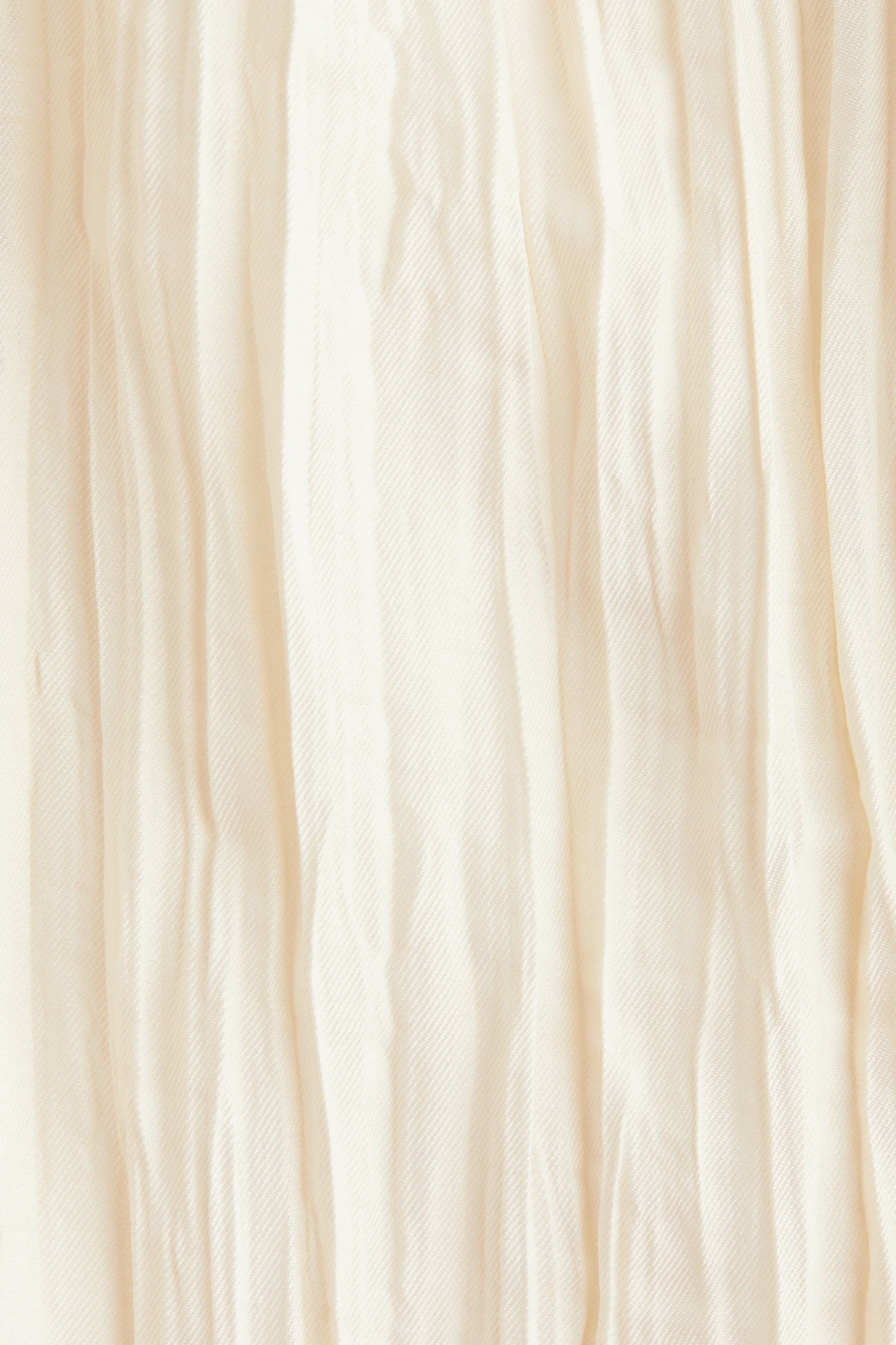 View larger image: A light beige fabric is presenting a textured surface with numerous vertical pleats and soft folds. The material is exhibiting a subtle diagonal twill weave pattern.
