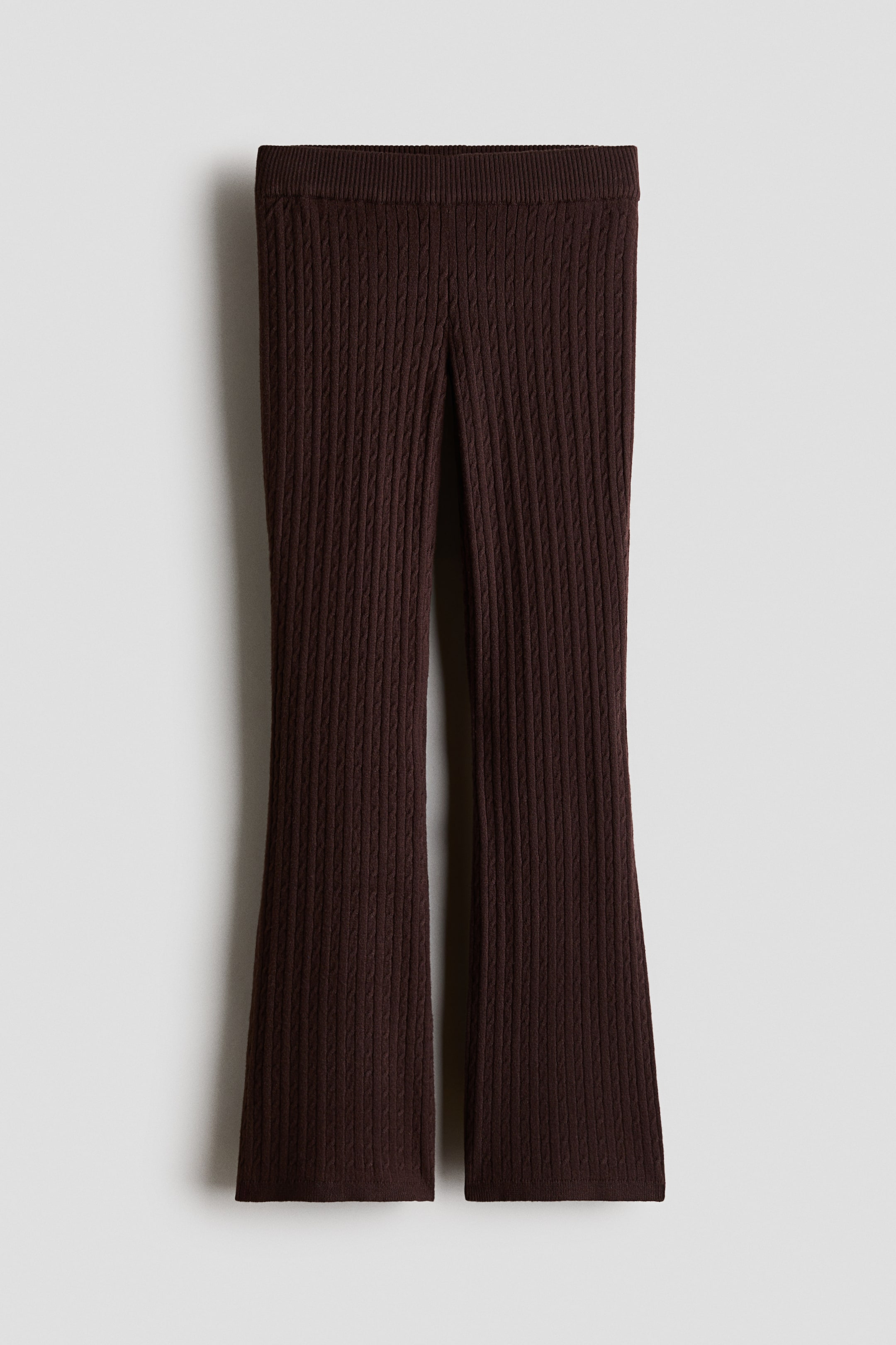 Agrandir l'image: Des leggings en maille torsadée marron foncé présentent une taille côtelée élastiquée, des jambes évasées et de fines côtes aux ourlets, présentés de face.