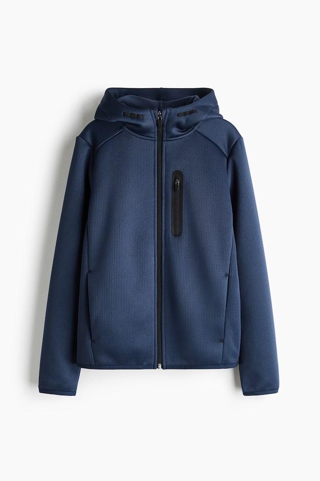 A blue zip-up hooded jacket is shown from the front, featuring a textured, finely ribbed fabric and a full-length black front zip. It is designed with an attached hood, a vertical zip-pocket on the left chest with black bonding, and long sleeves with neat, narrow cuffs. - 1