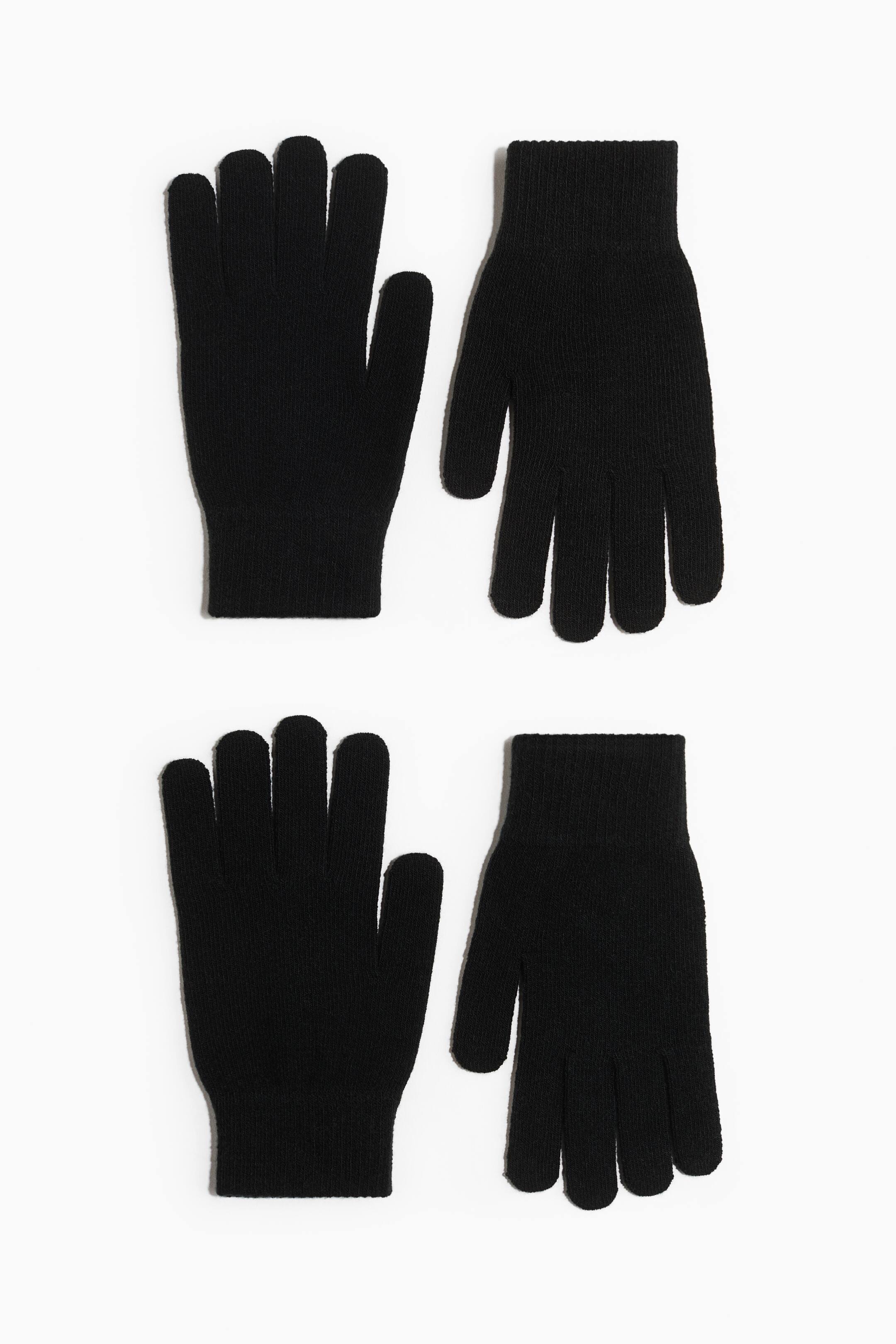 View larger image: Two pairs of black knitted gloves are laid flat, each glove featuring a five-finger design and ribbed cuffs.