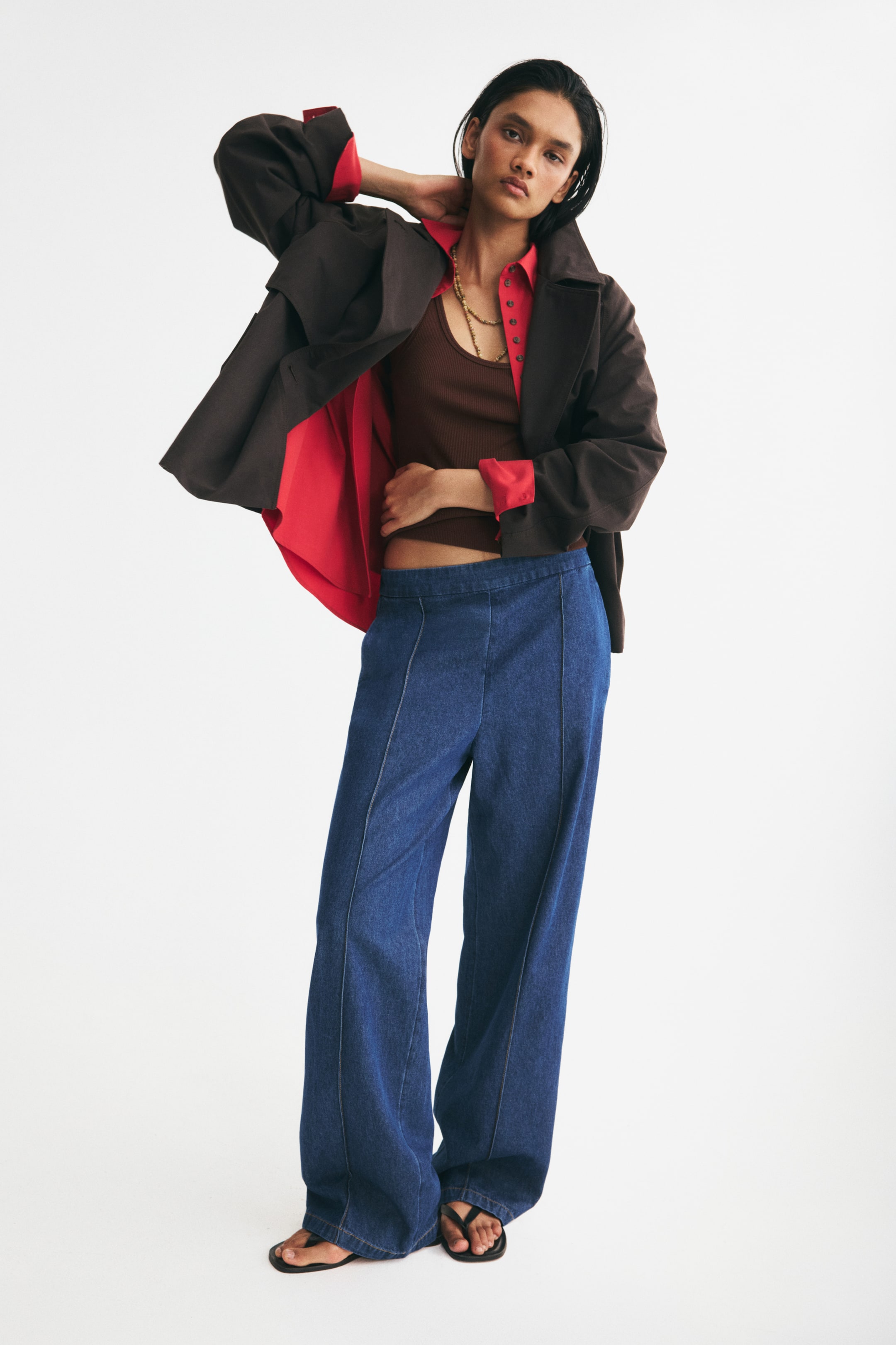 View larger image: The model is wearing relaxed-fit cotton denim trousers with a regular waist and straight legs, featuring sewn-in creases down the front.