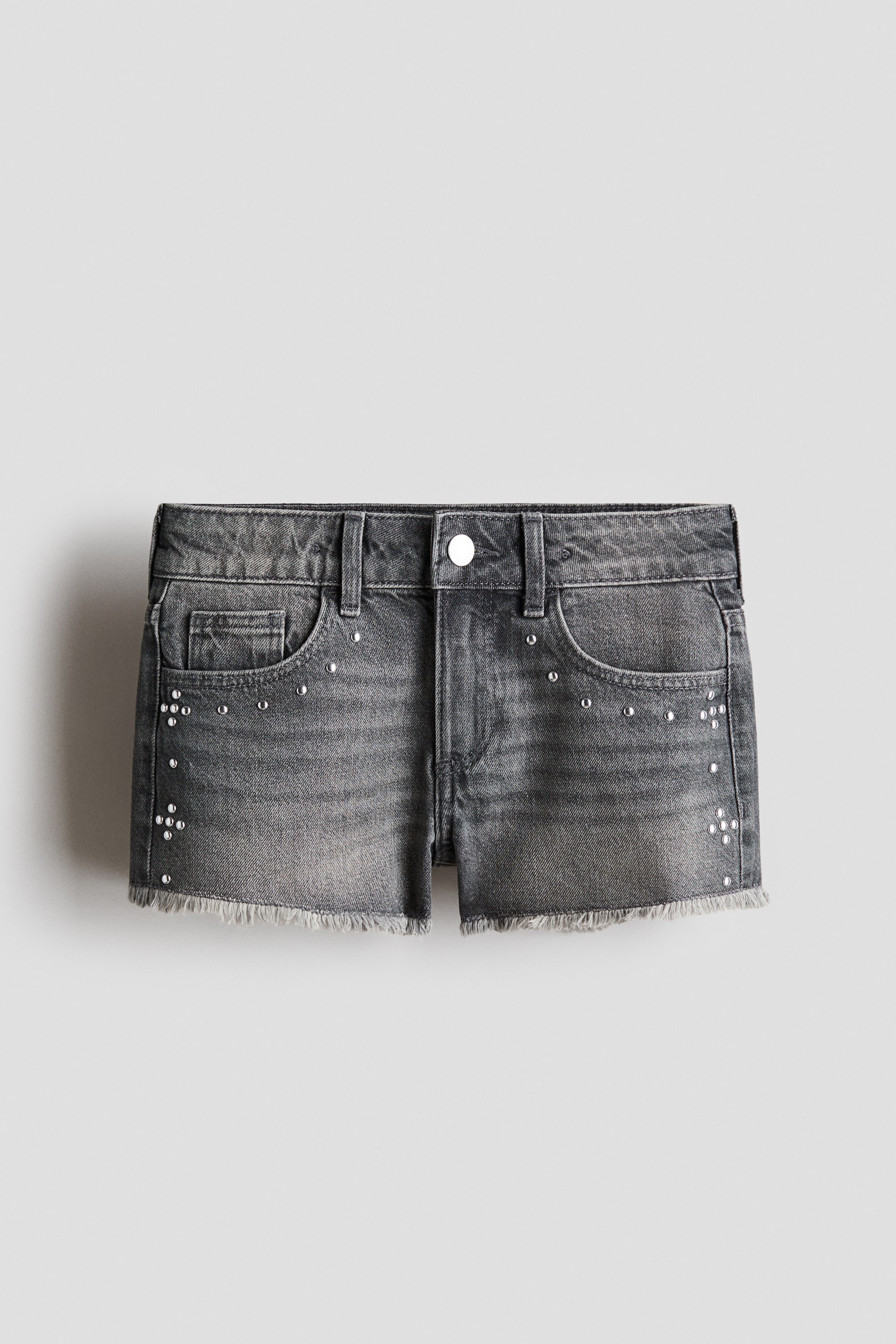 Se større billede: 5-lomme shorts i falmet grå denim har en frontvisning med spredte sølvfarvede nitte detaljer. De er designet med en enkelt knaplukning, lynlås, forlommer og rå kanter.