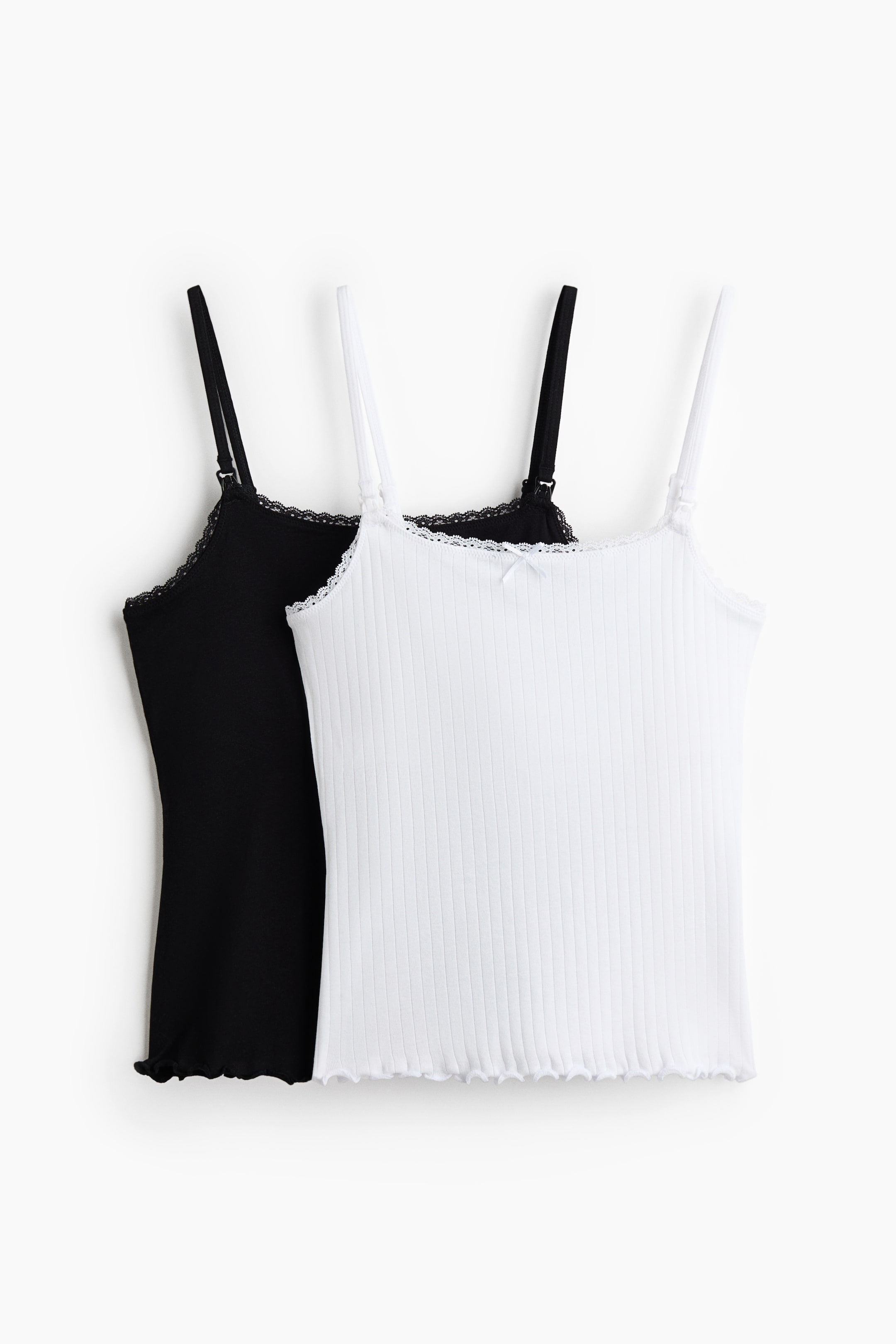 View larger image: Two camisoles are visible, one in white and one in black, both featuring a ribbed texture, thin adjustable spaghetti straps, a lace-trimmed straight neckline, and a lettuce hem. The white camisole is facing front and is also displaying a small bow at the centre of its neckline.