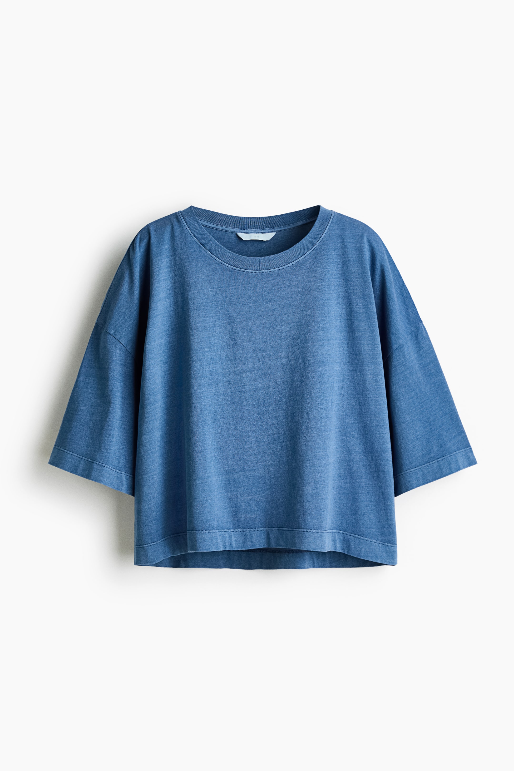 View larger image: A blue washed t-shirt showcases a relaxed fit, front-facing. It features a crew neck, dropped shoulders, wide three-quarter length sleeves, and a straight, slightly cropped hem.