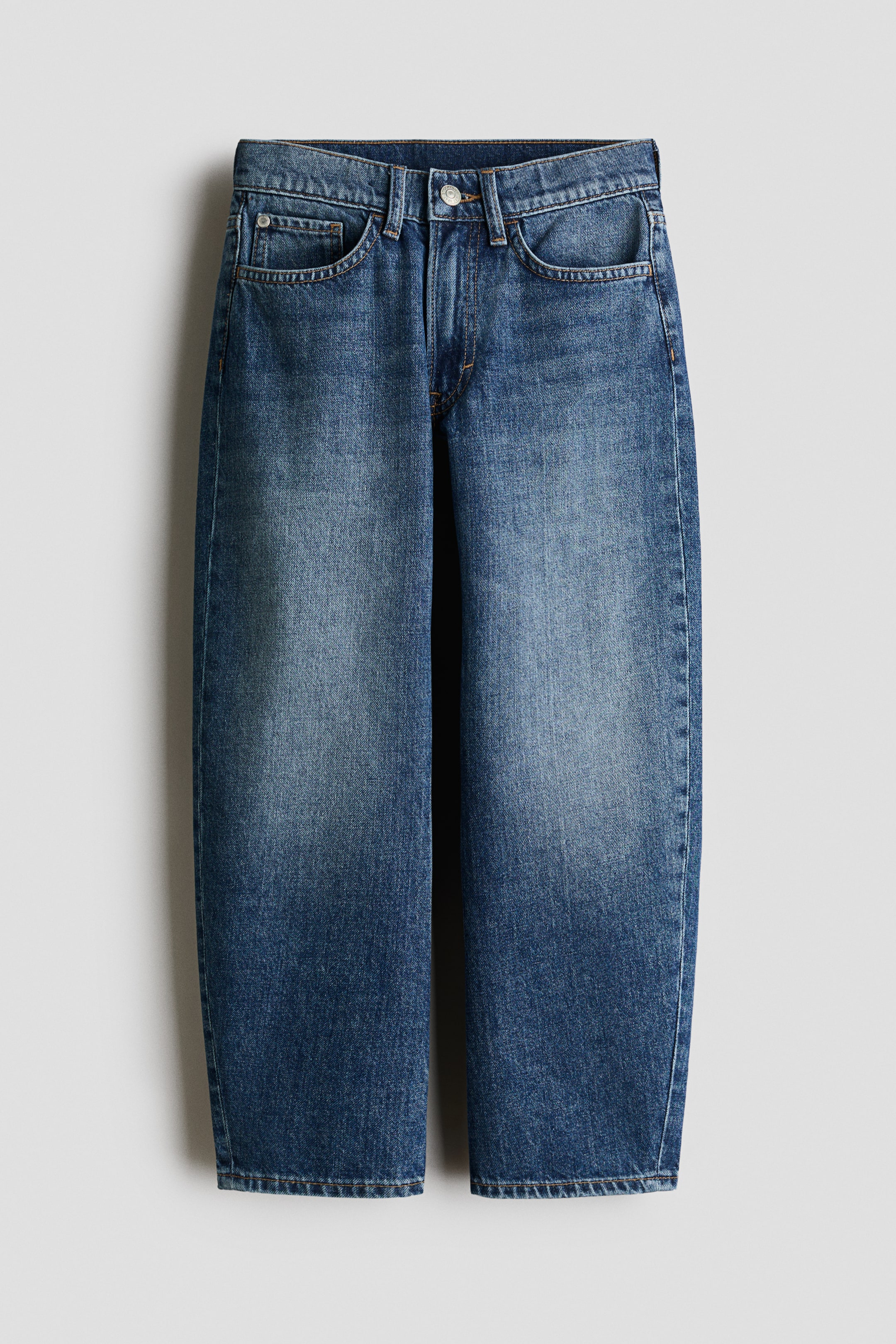Se større billede: Blå denimjeans vises forfra med en falmet middelblå vask langs lårene og et klassisk design med fem lommer. Jeansene har en straight-leg pasform med kontrastsyninger, bæltestropper og en lukning med sølvfarvet knap i linningen.