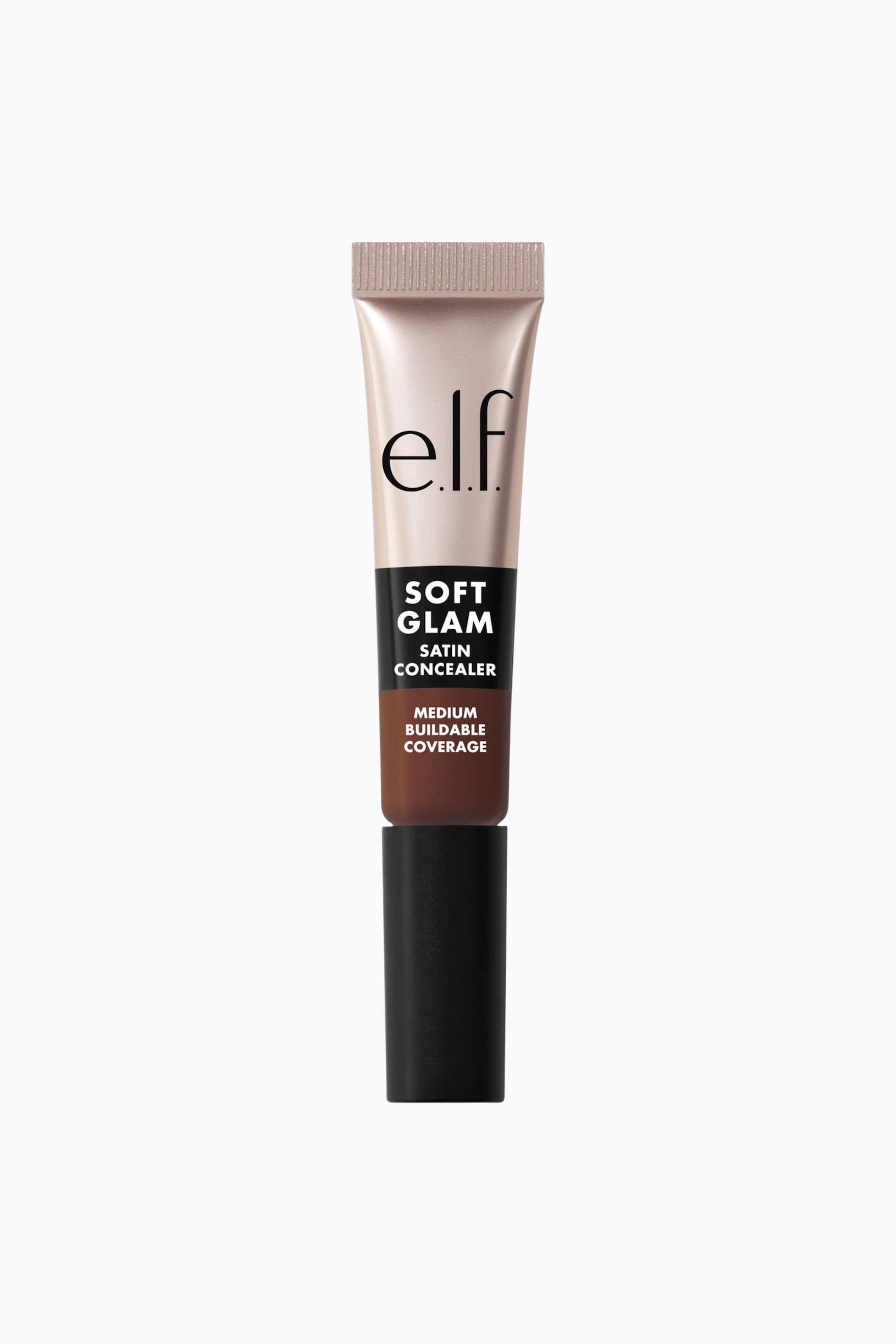 Vis større bilde: En e.l.f. Soft Glam Satin Concealer-tube står oppreist og viser en lys, skimrende beige øverste del med en ribbet krimpforsegling og e.l.f.-logoen. Et svart bånd har teksten 'Soft Glam Satin Concealer', som går over i en seksjon i mellombrun nyanse med teksten 'Medium Buildable Coverage', og et svart lokk utgjør bunnen av tuben.