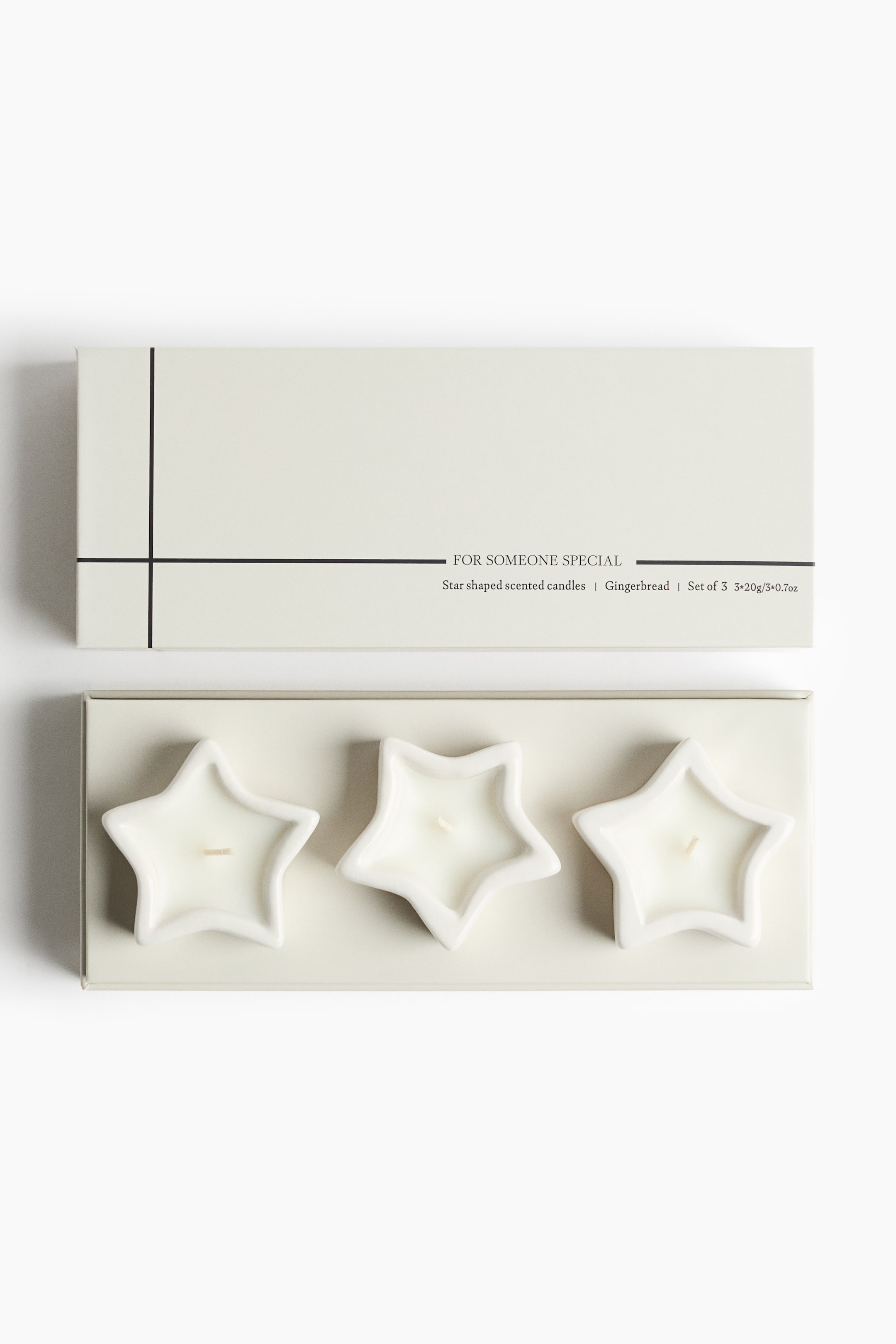 View larger image: A set of three white, star-shaped scented candles in ceramic holders is resting inside an open, cream-coloured rectangular box. The box lid is lying above the base, featuring minimalist black intersecting lines and printed text that reads "FOR SOMEONE SPECIAL."