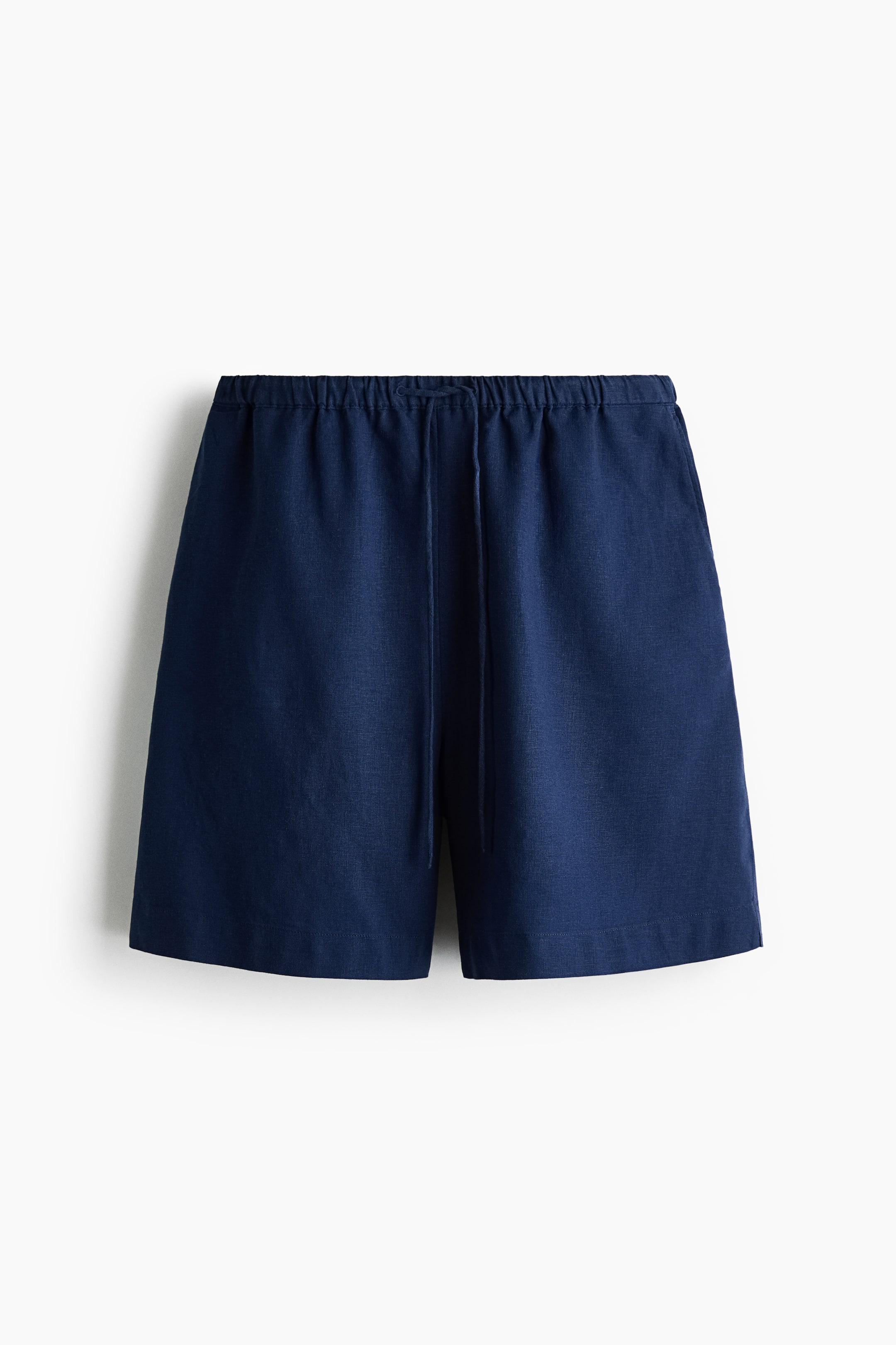 Agrandir l'image: Shorts à coupe ample présentés de face, dans une couleur bleu foncé, avec une taille élastiquée à cordon de serrage et des poches latérales en diagonale. Ils sont confectionnés dans un tissage léger en mélange de lin et de viscose.