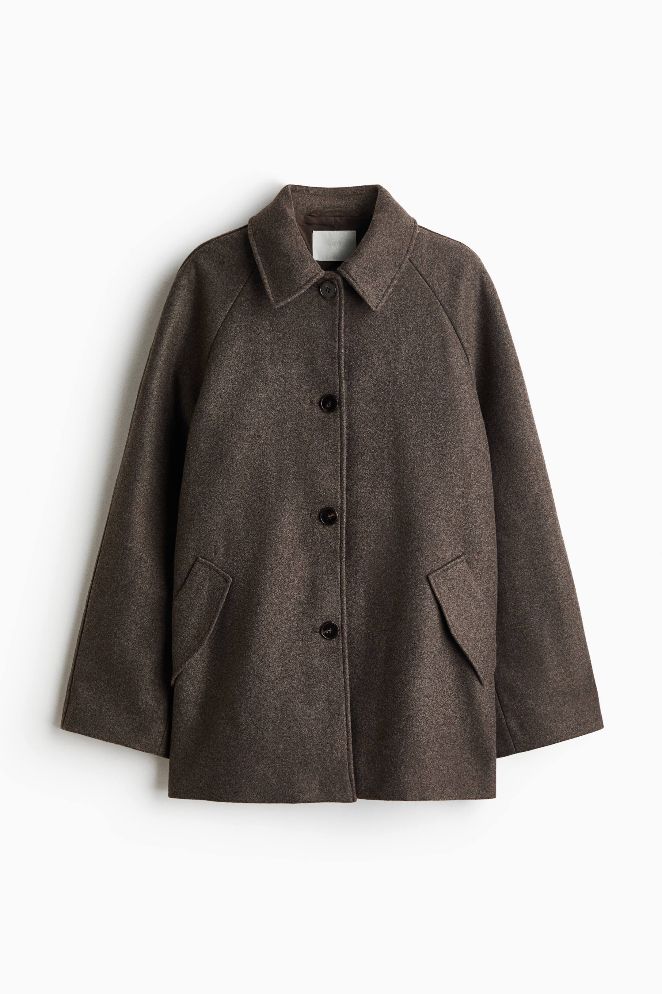 View larger image: A dark brown, textured wool-blend coat is shown from the front, featuring a pointed collar, a button-front closure with four dark buttons, raglan sleeves, and two front patch pockets with pointed flaps.