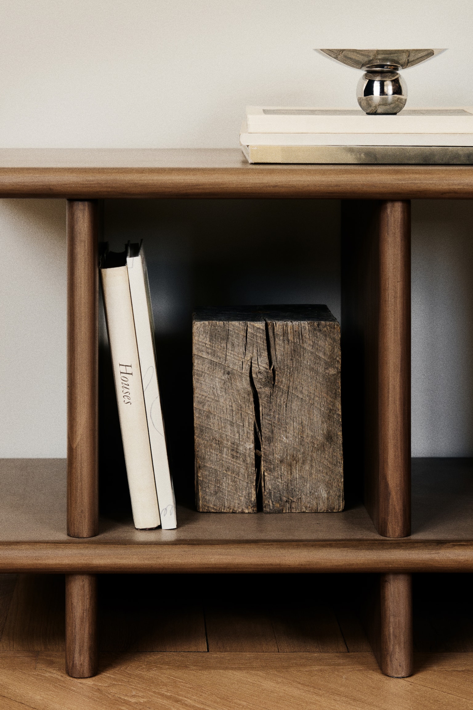 A dark brown wooden shelving unit boasts a long rectangular top shelf situated above a slightly shorter rectangular bottom shelf. Four vertical dividers support the top shelf, forming three open compartments, with matching vertical supports extending beneath the bottom shelf. - 1