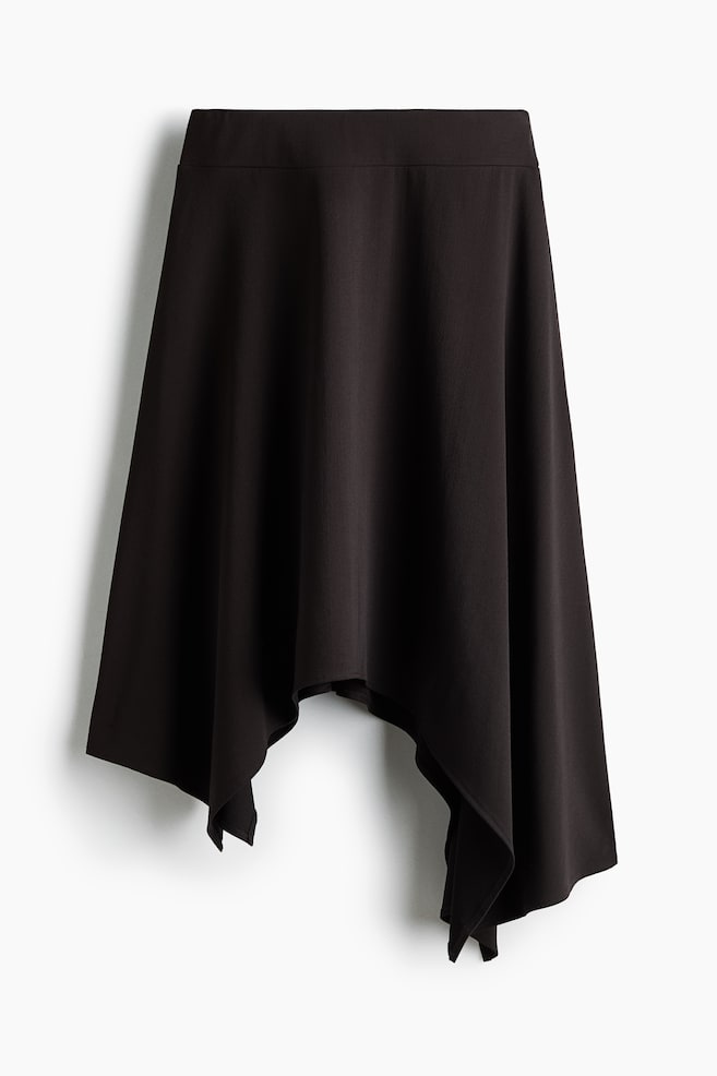A dark brown skirt is hanging facing the front, showcasing a wide, flat waistband and a fluid, flared drape. The skirt is featuring a dramatic asymmetrical handkerchief hemline with pointed, cascading folds on the sides. - 1
