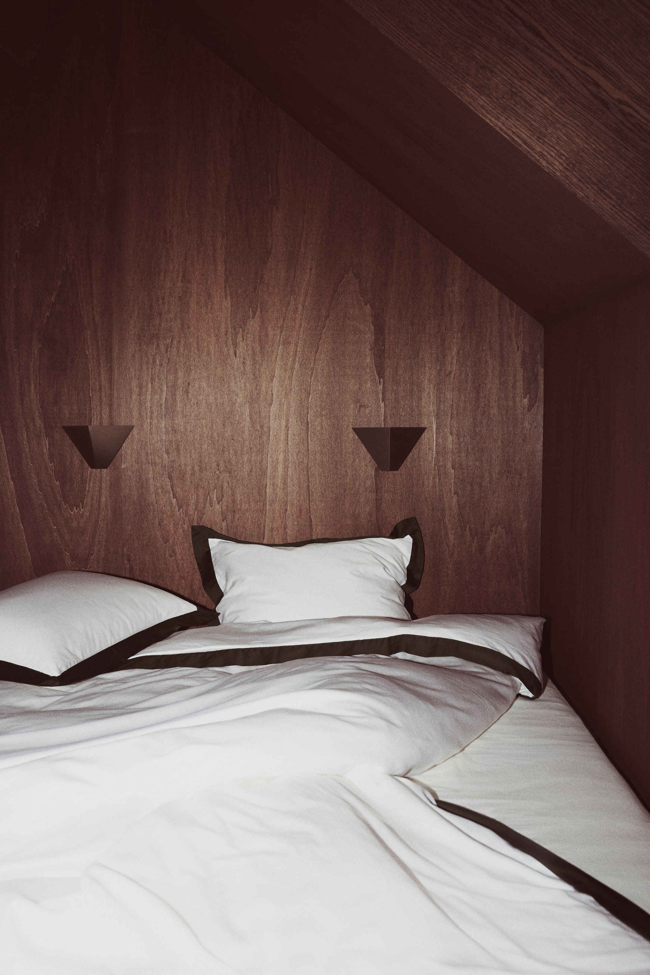 Visualizza l'immagine ingrandita: Un completo copripiumino bianco è adagiato su un letto, mettendo in risalto un ampio bordo decorativo verde scuro lungo i bordi del copripiumino e delle federe abbinate. Il tessuto presenta una lieve lucentezza, con il copripiumino ripiegato all’indietro che cade in avanti e le due federe coordinate appoggiate dietro.