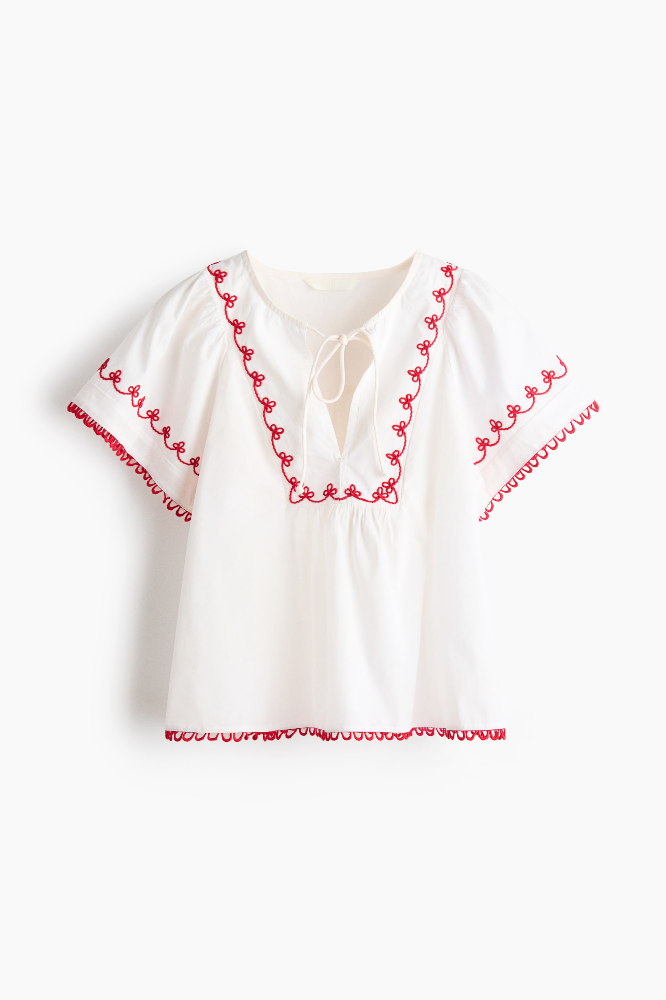 View larger image: A white short-sleeved blouse showcases its front view, crafted from crisp cotton poplin. It boasts a relaxed fit, a round neckline with a V-shaped opening and narrow ties, and a bib front with gathers. Red embroidered details trace the neckline and sleeves, while picot trim finishes the cuffs and hem.