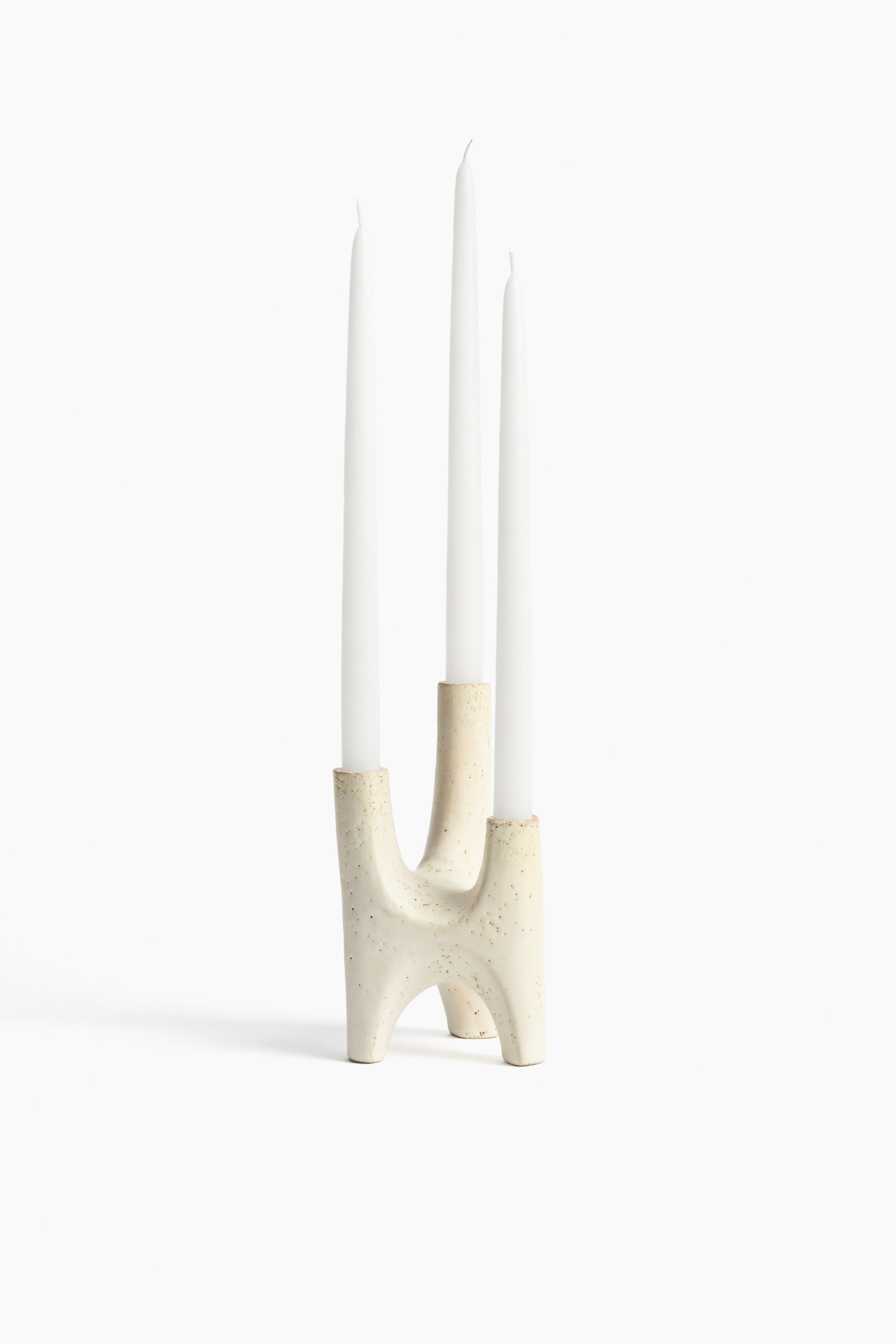 View larger image: A stoneware candelabra showcases a sculptural, organic design with three arms reaching upwards to hold candles, viewed from the front. It features an expressive, speckled glaze and holds three white taper candles.