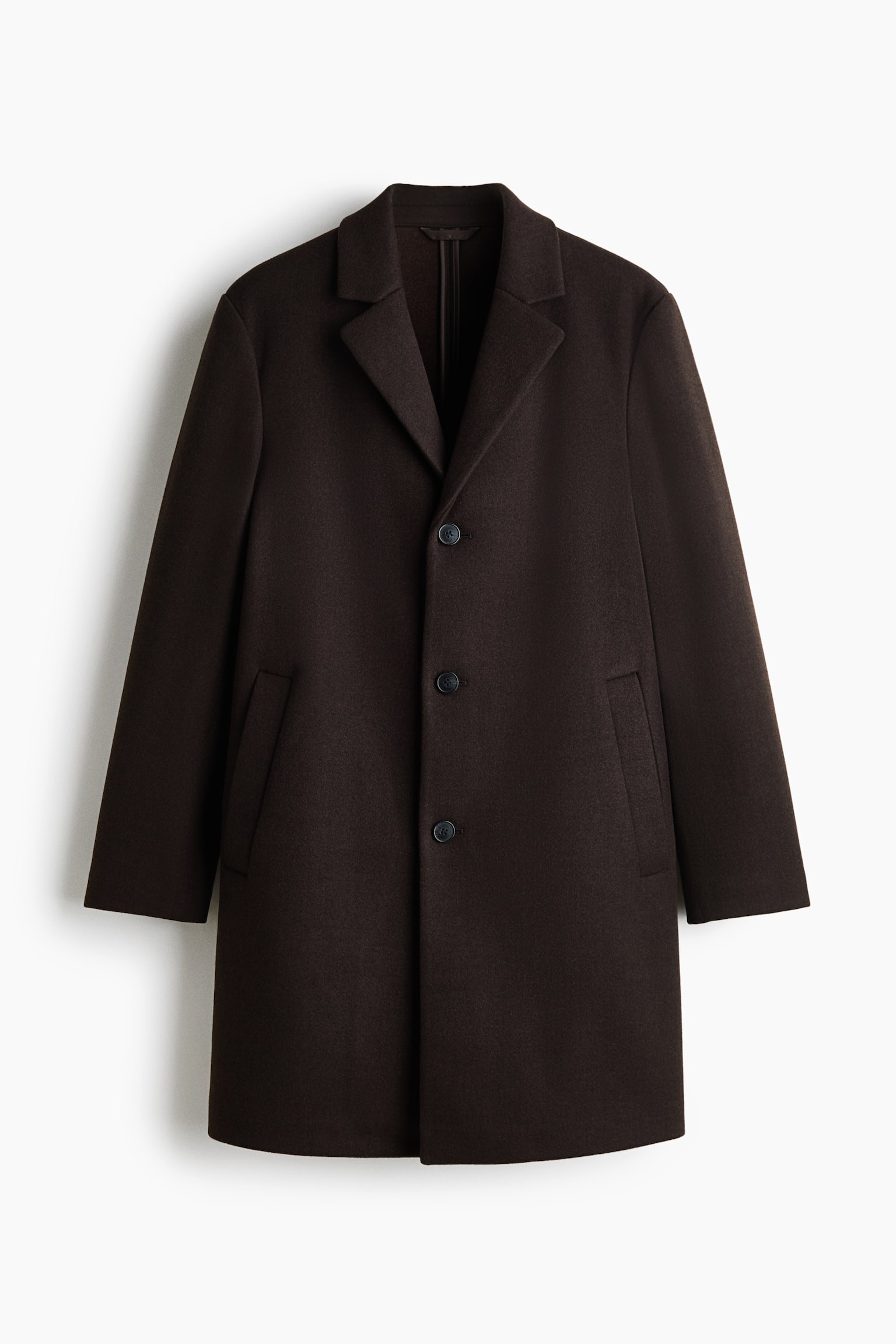 Un cappotto marrone scuro, monopetto, Ã¨ appeso frontalmente, con revers a lancia, chiusura frontale a tre bottoni e tasche laterali a filetto oblique.