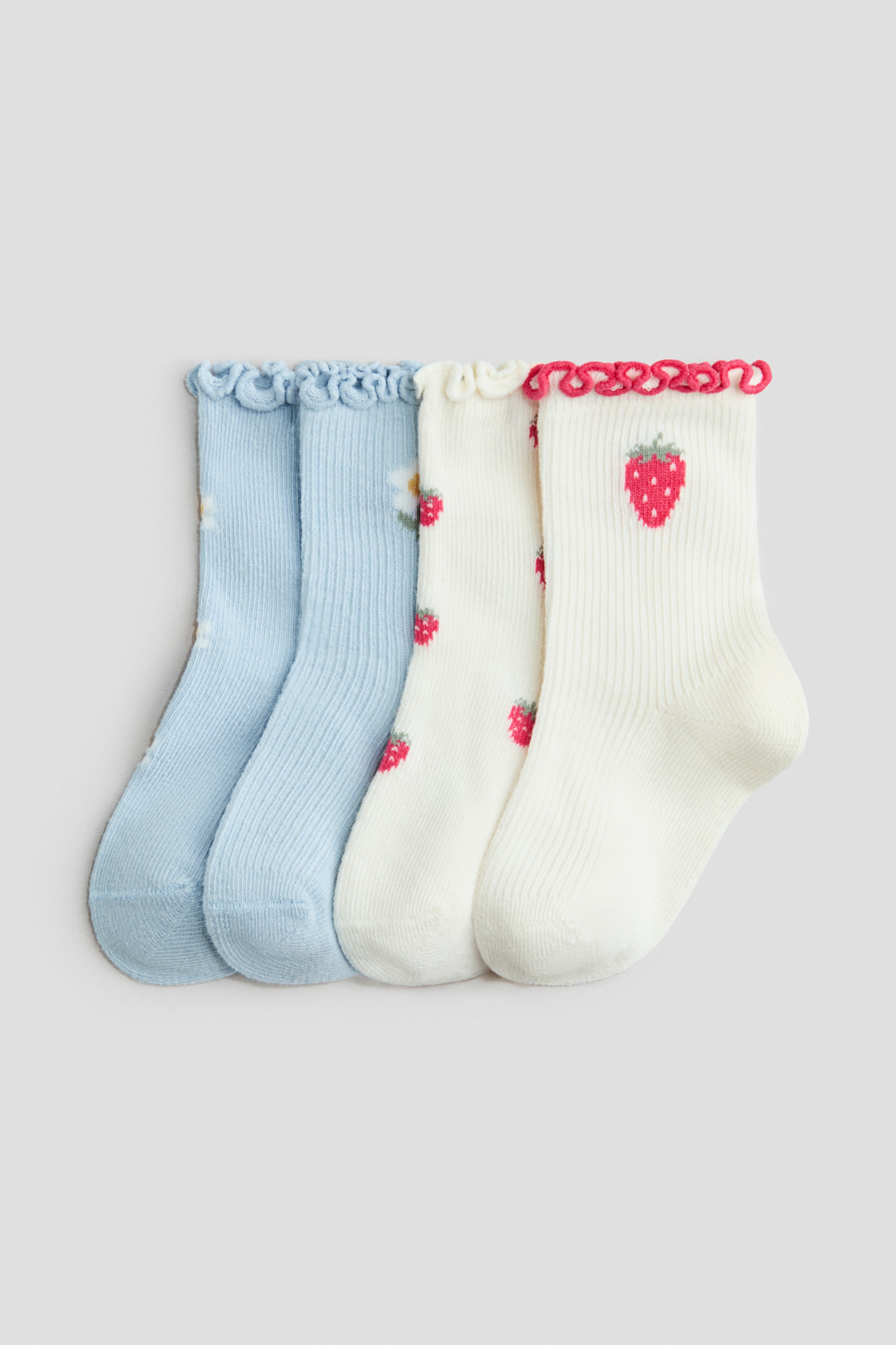 Agrandir l'image: Un ensemble de quatre chaussettes en mélange de coton tricoté est présenté de face, avec des textures côtelées et des bordures festonnées surjetées. Les deux chaussettes bleu clair arborent des motifs de marguerites blanches avec des bordures bleues assorties, et les deux chaussettes blanc cassé affichent des motifs de fraises rouges, l'une ayant une bordure blanc cassé et l'autre une bordure rouge.