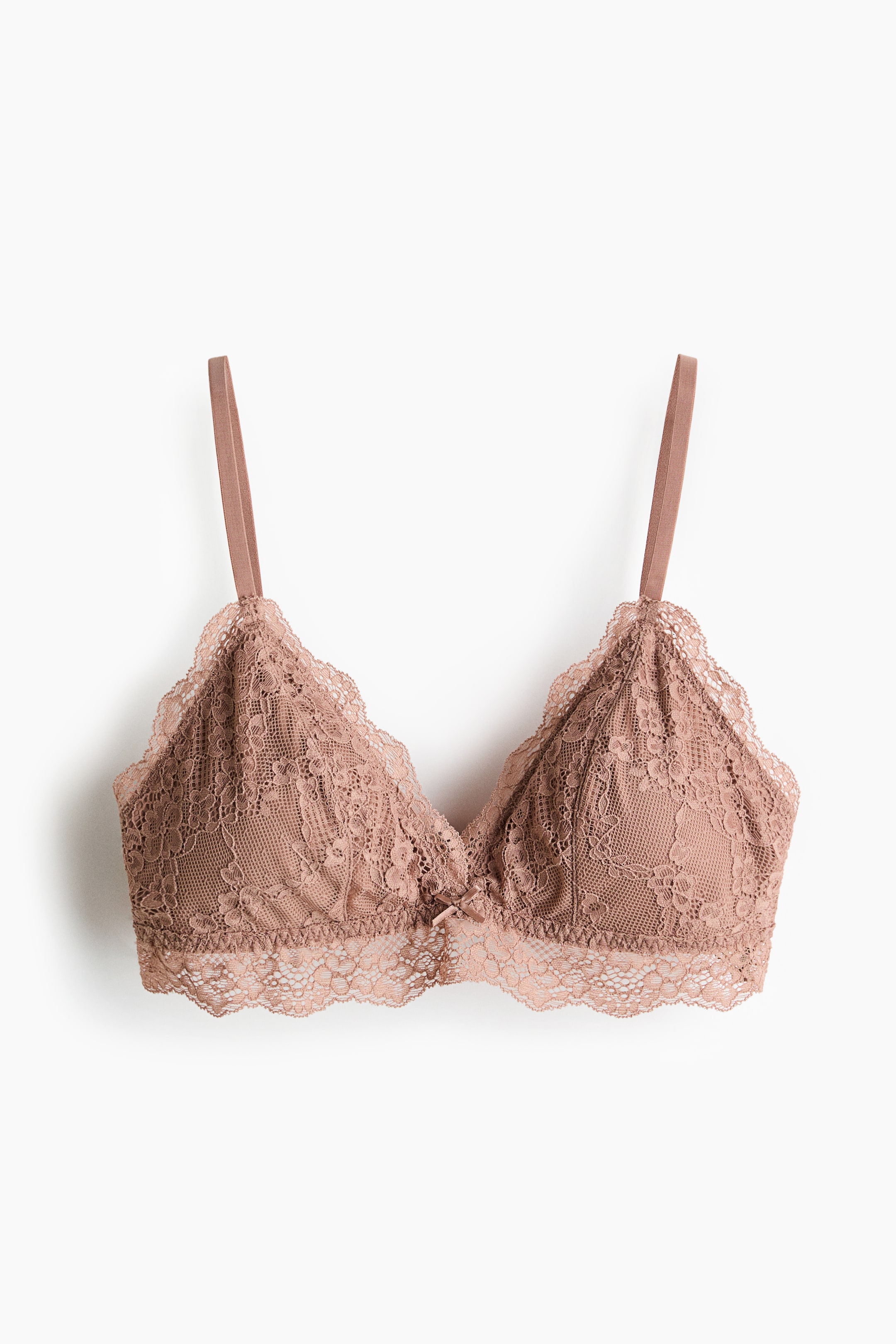 Ampliar la imagen: Bralette de encaje rosa empolvado presentado de frente, con copas triangulares y un ribete de encaje festoneado a lo largo de los bordes y de la banda inferior. También muestra tirantes delgados y ajustables y un pequeño lazo en el centro.