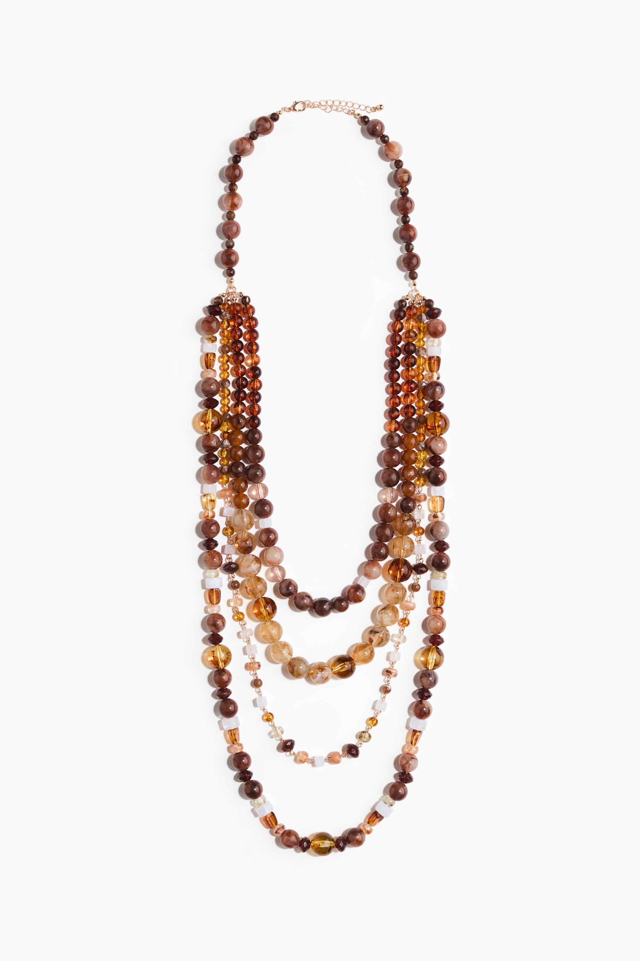 View larger image: "A multi-strand beaded necklace showcases its front, adorned with a variety of round and rectangular beads in diverse shades of brown, amber, and golden yellow. Multiple strands gracefully cascade downwards, forming a layered effect, and are linked by a gold-toned adjustable chain at the top."