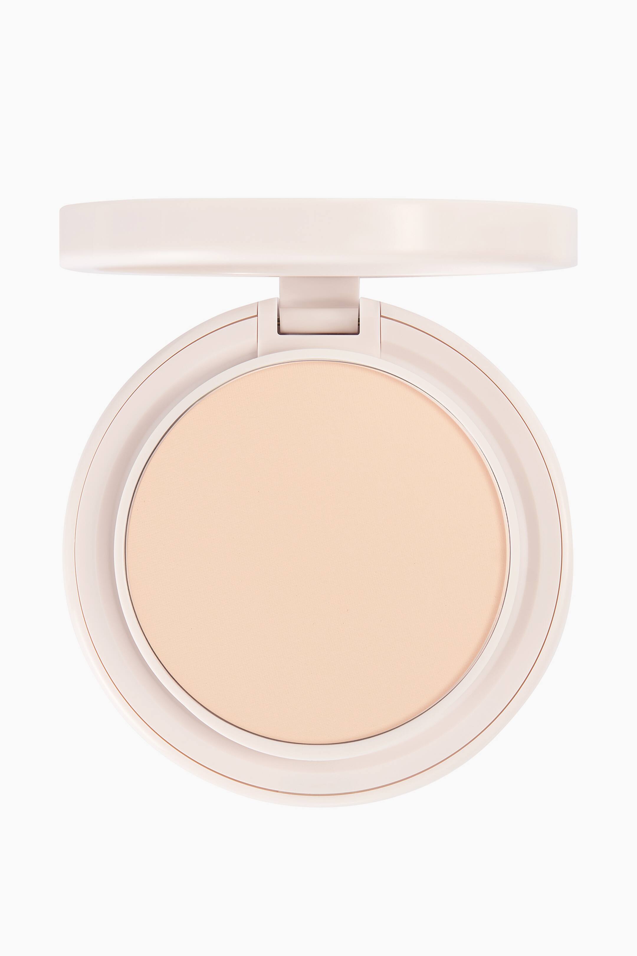 Visa större bild: Natural Blur Powder Foundation vilar i en öppen, rund, ljusrosa dosa och visar en jämn, cirkelformad yta av pressat puder i ljusbeige. Dosan är vänd framåt med locket uppfällt upptill, vilket ger en tydlig vy av produktens struktur och nyans.