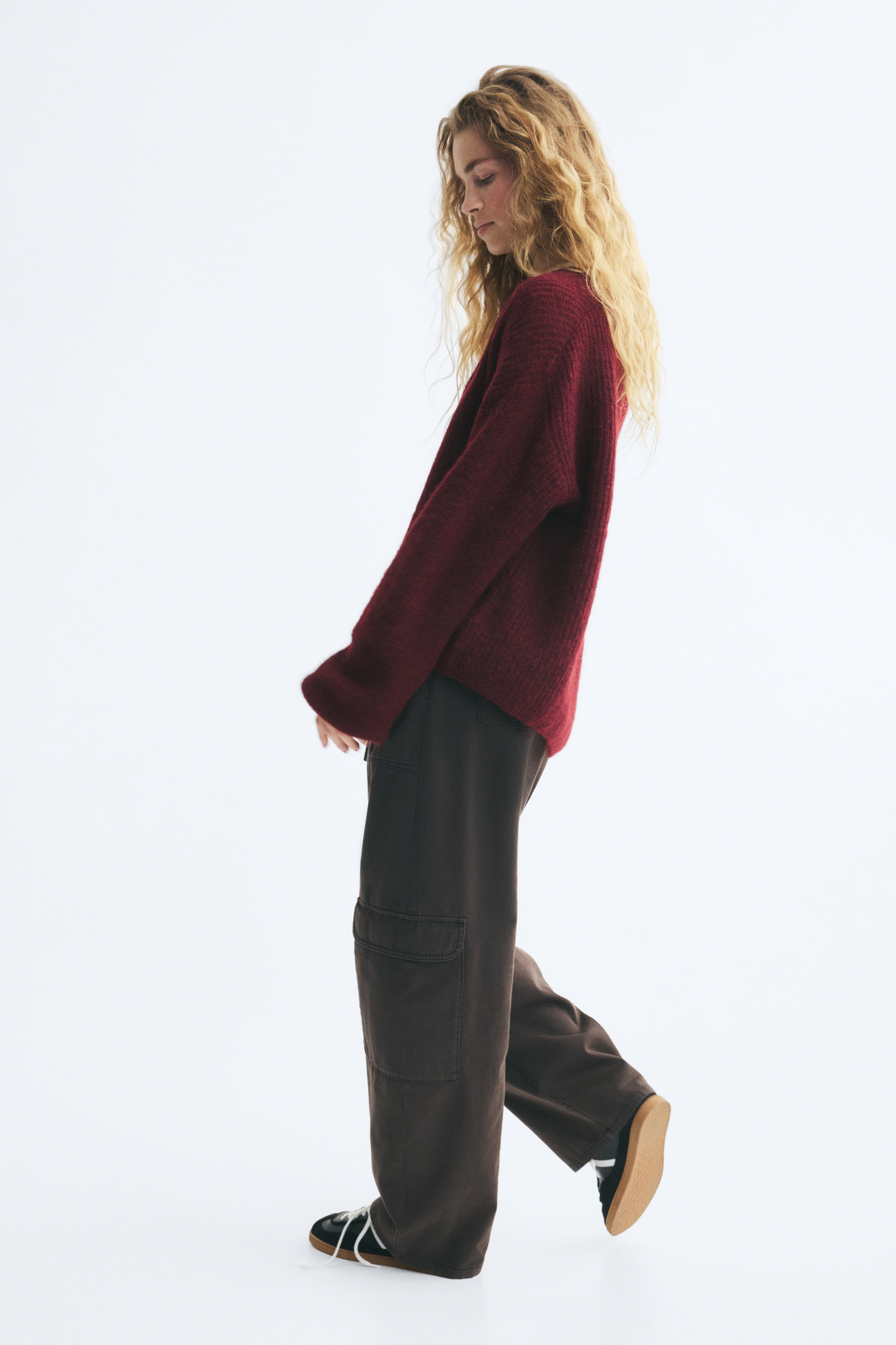 Má»t chiáº¿c cardigan len dÃ¡ng rá»ng mÃ u Äá» burgundy ÄÆ°á»£c chá»¥p chÃ­nh diá»n, ná»i báº­t vá»i thiáº¿t káº¿ má» phÃ­a trÆ°á»c, vai rÆ¡i vÃ  ÄÆ°á»ng cá» chá»¯ V sÃ¢u. Ão cÃ³ tay dÃ i phá»ng vá»i bo tay gÃ¢n vÃ  cháº¥t liá»u dá»t kim gÃ¢n má»m máº¡i, bá» máº·t cháº£i nháº¹ phá»§ kháº¯p toÃ n bá» sáº£n pháº©m.