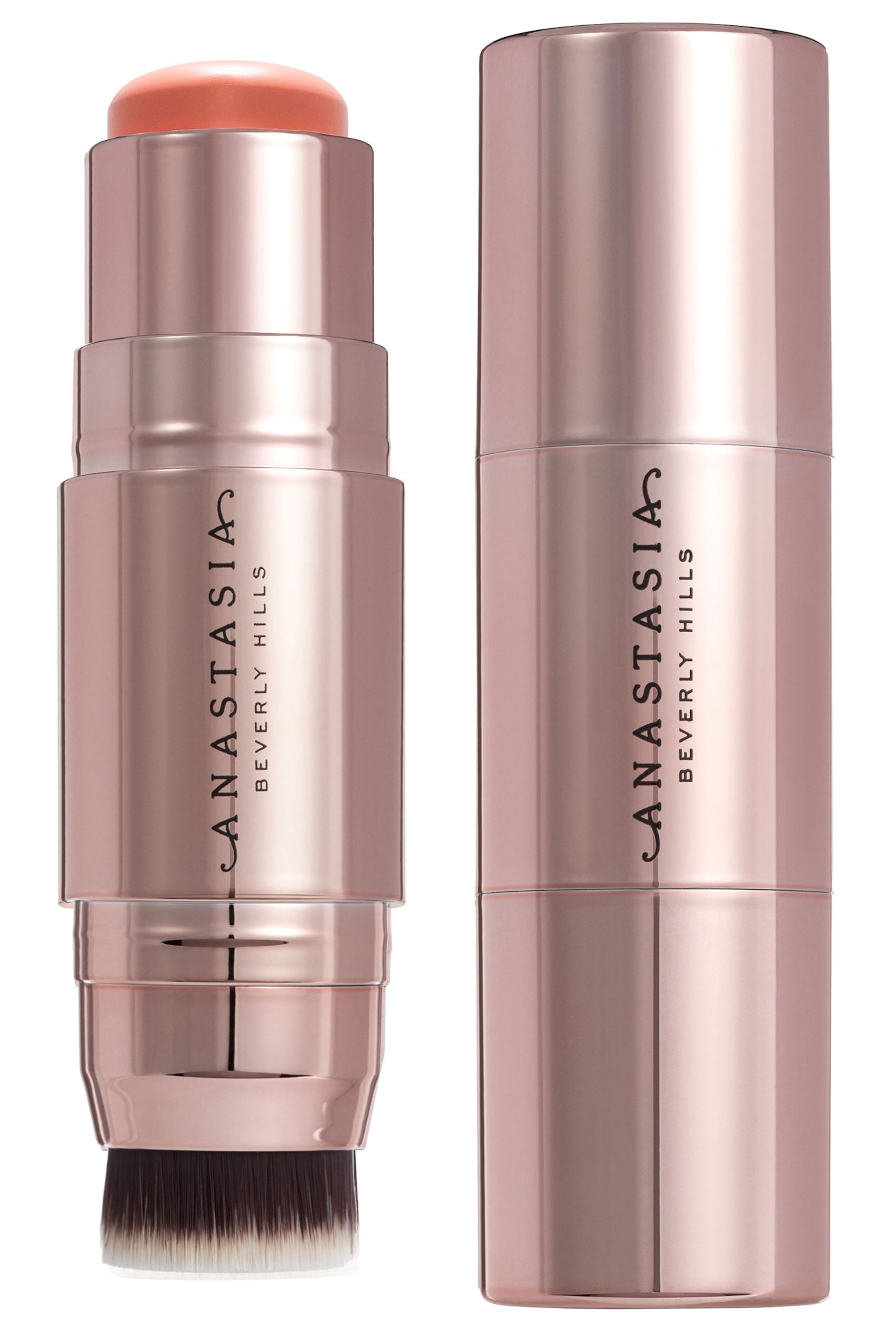 Se større billede: To rosaguld kosmetikstifter står oprejst, begge med mærkenavnet "ANASTASIA BEVERLY HILLS" lodret på deres sider. Den venstre stift viser et eksponeret fersken-orange cremeprodukt øverst og en to-tonet børsteapplikator i bunden, mens den højre stift viser sin fuldt lukkede, glatte indpakning.