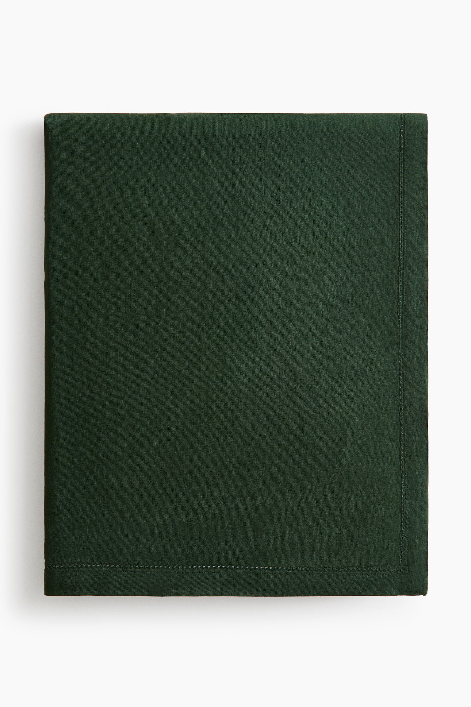 A dark green cotton canvas tablecloth is shown folded into a neat rectangle, displaying its smooth, matte texture. The front view highlights a 2.5 cm hem with delicate hemstitch detailing running along the edges.