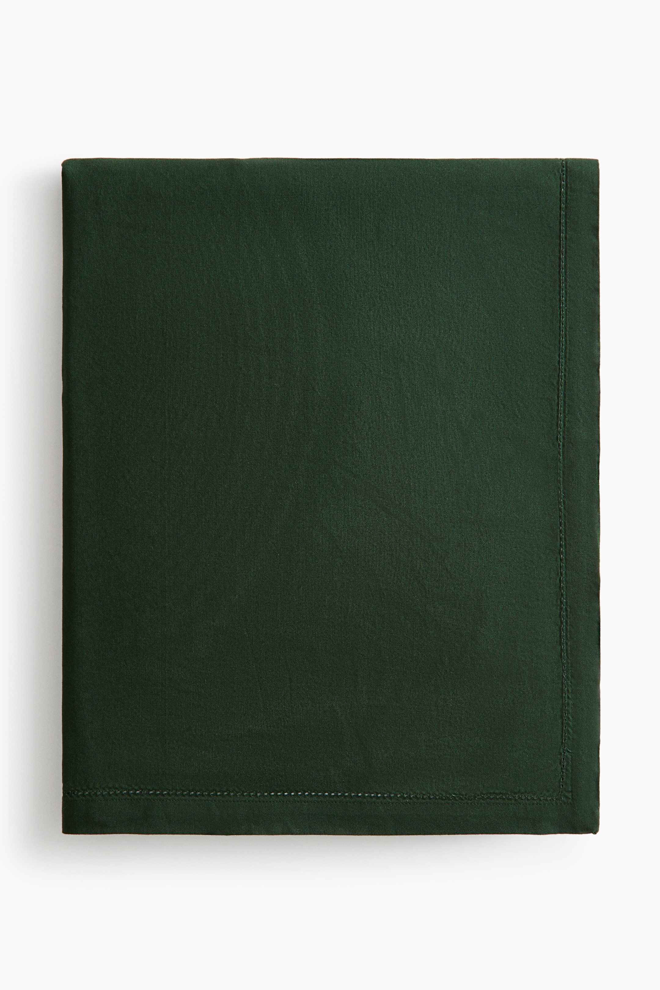 View larger image: A dark green cotton canvas tablecloth is shown folded into a neat rectangle, displaying its smooth, matte texture. The front view highlights a 2.5 cm hem with delicate hemstitch detailing running along the edges.
