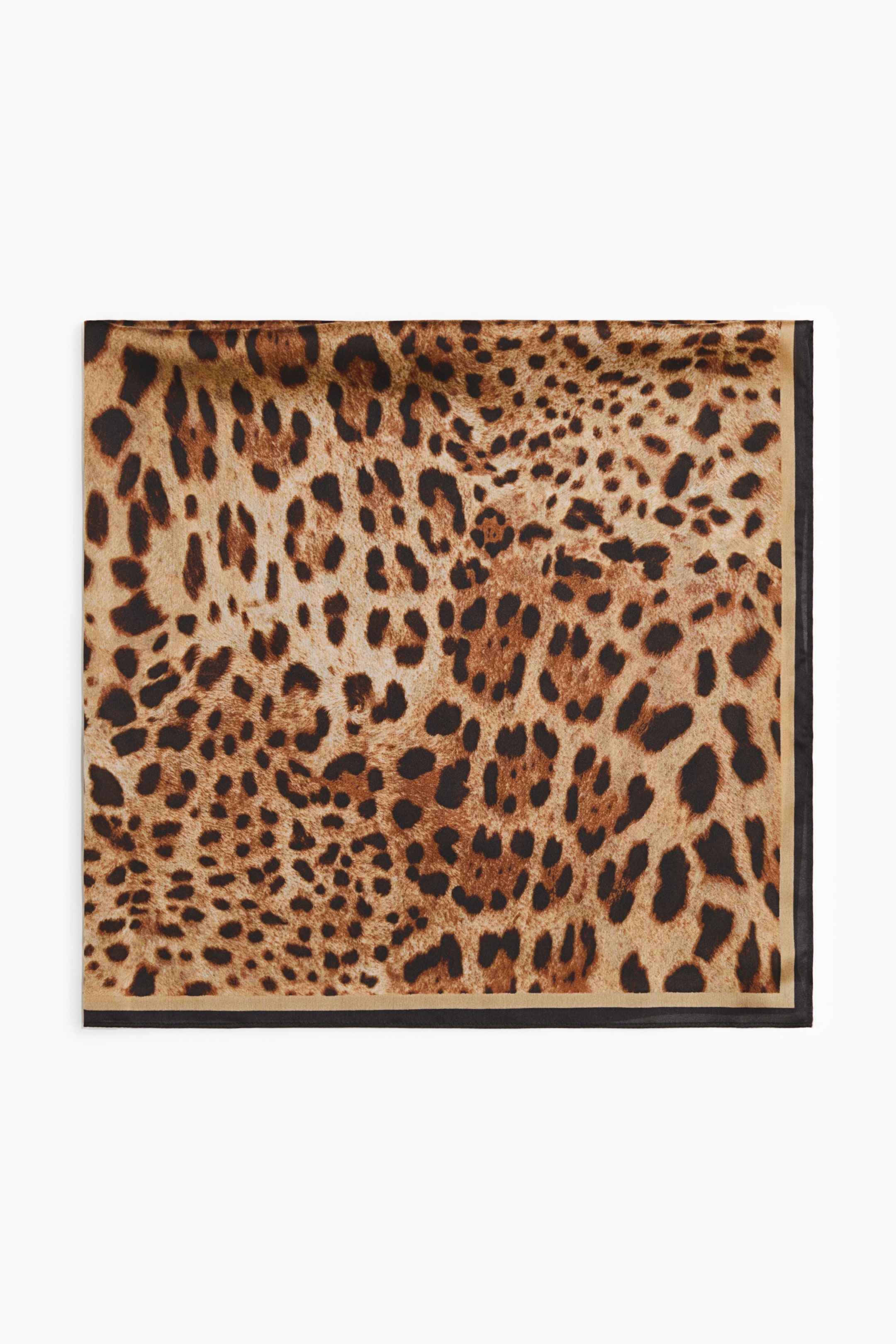 Agrandir l'image: Un foulard carré est posé à plat, présentant un motif léopard dans différentes nuances de brun et de noir sur un fond beige. L'imprimé est encadré par une fine bordure beige sur les quatre côtés, et une bordure noire plus large est présente le long des bords inférieur et droit.