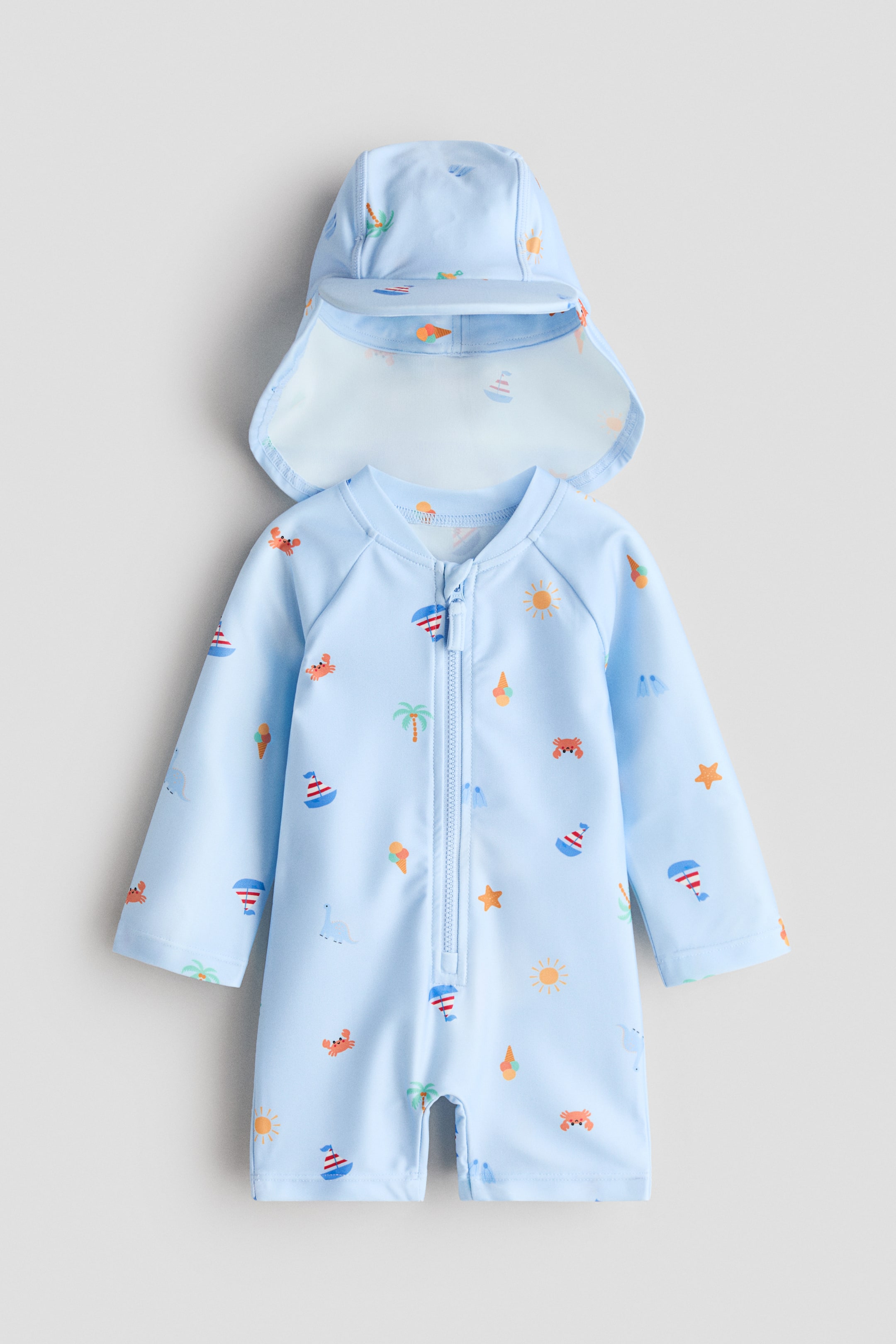 View larger image: A light blue sun protection set includes a swimsuit and a matching cap, both adorned with vibrant summer-themed illustrations. The swimsuit features a front zipper, an anti-chafe chin guard, long raglan sleeves, short legs, and a small stand-up collar. The cap comes with a front peak and a back flap.