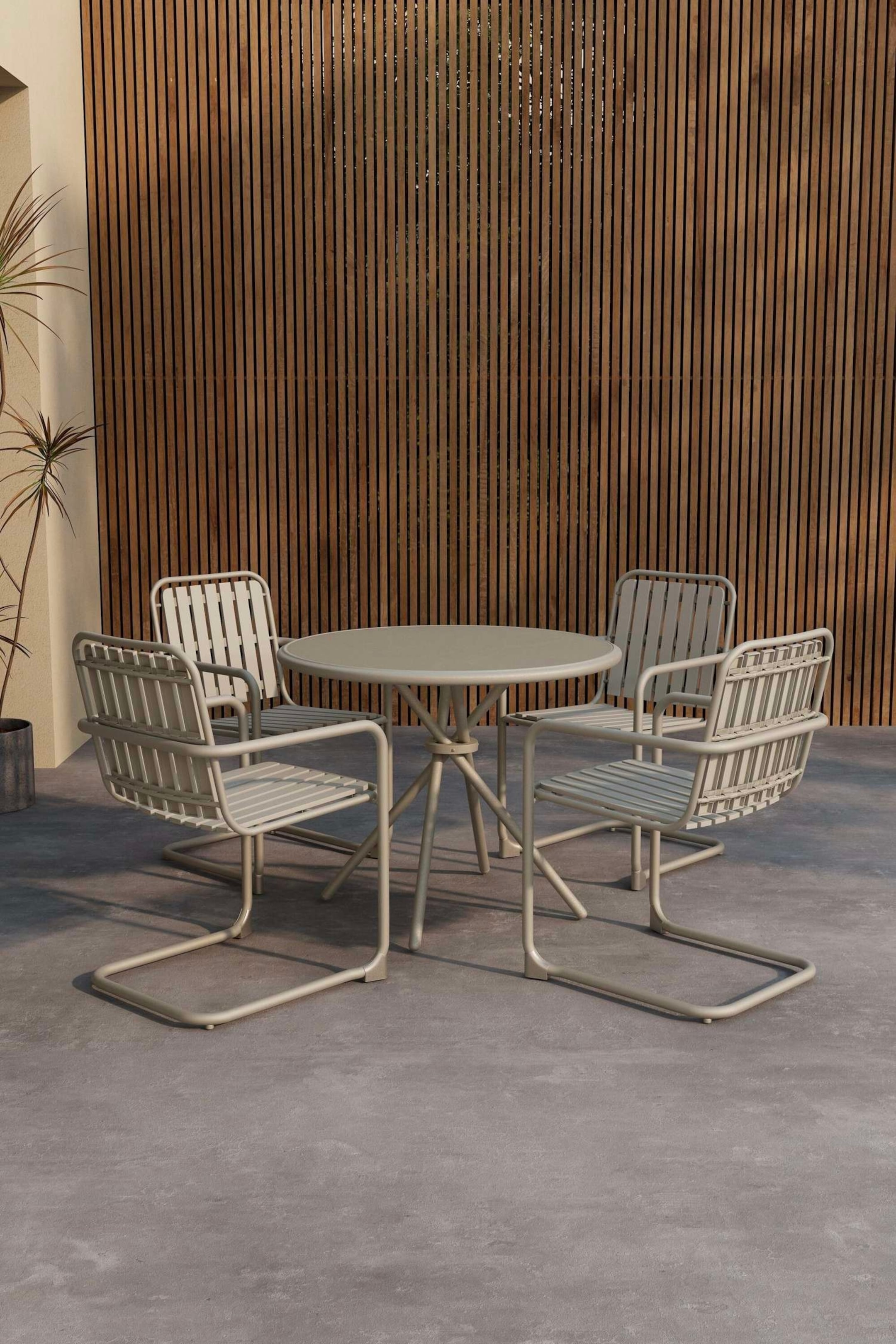 Visualizza immagine più grande: Un set da pranzo per patio di colore grigio chiaro è composto da un tavolo rotondo e quattro sedie, presentato da un'angolazione frontale destra. Il tavolo mostra una base centrale a piedistallo con gambe svasate, mentre ogni sedia presenta uno schienale e una seduta a doghe con braccioli diritti e una base a forma di U.