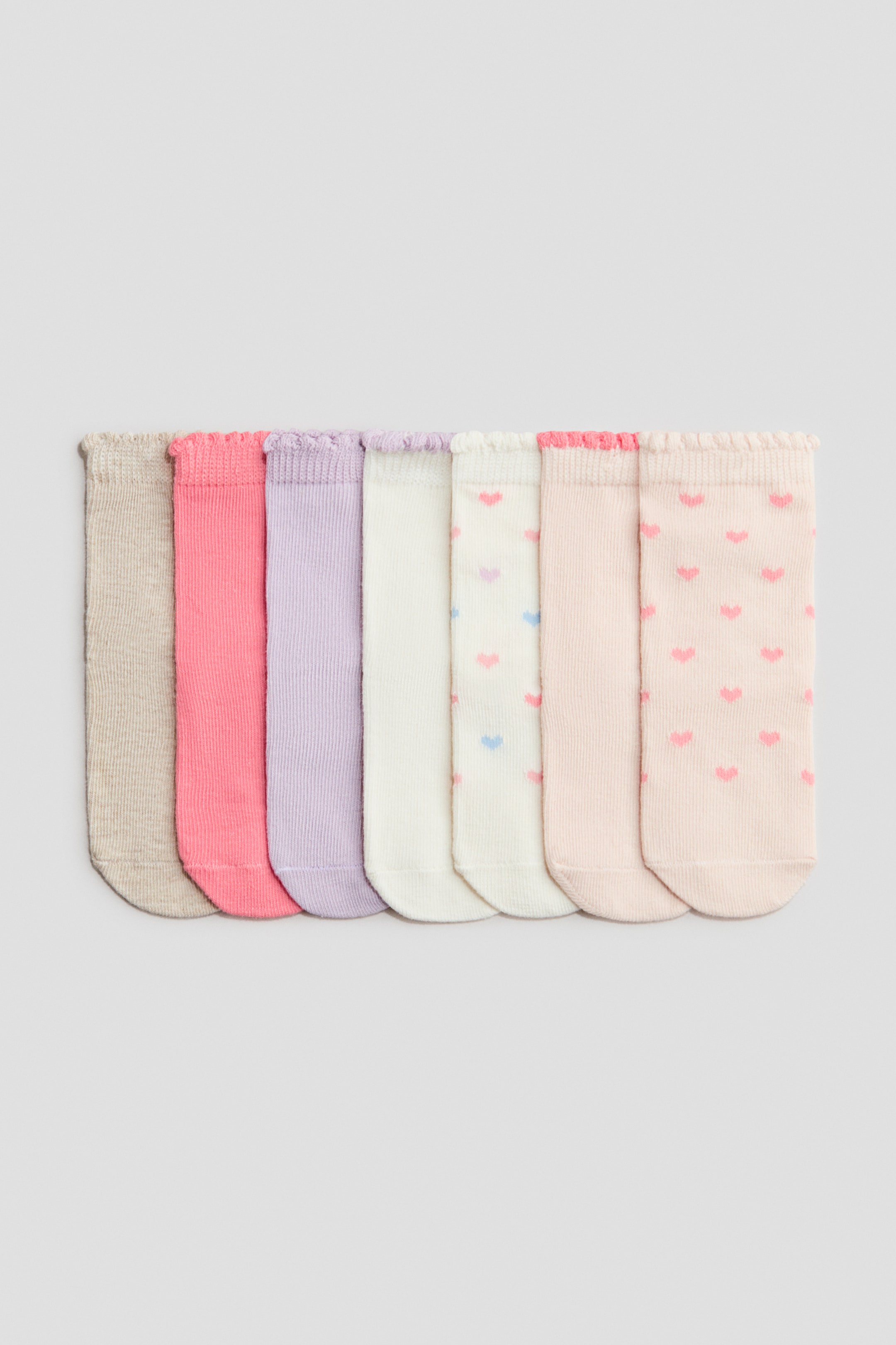 View larger image: Seven fine-knit socks are lying flat, presenting their fronts and showcasing various designs. 