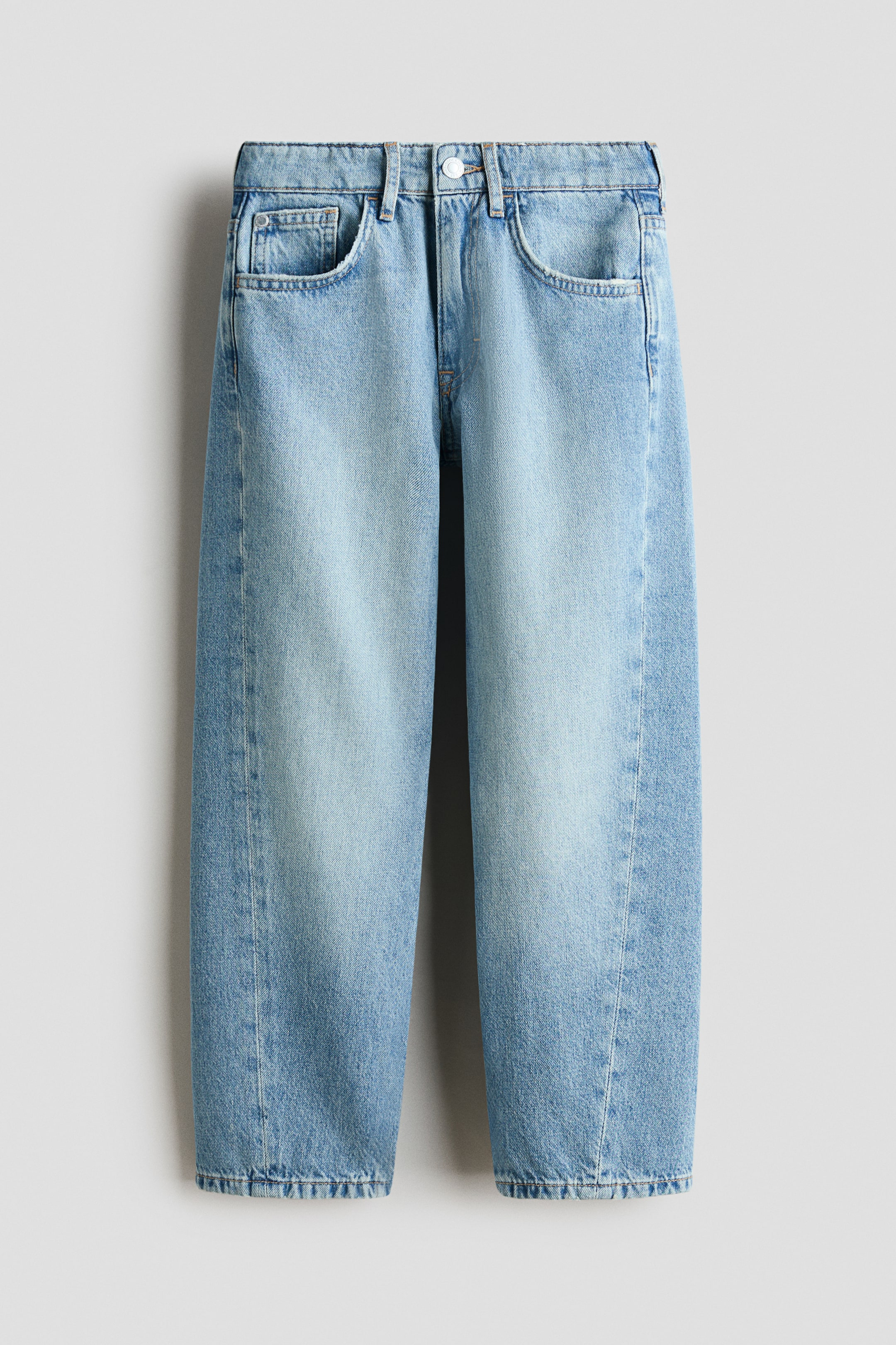 View larger image: Light blue denim jeans are showcased from the front, featuring a button fastening at the waist, two curved front pockets, and a small coin pocket. The jeans boast a relaxed fit with visible seam detailing running down the front of each leg and a finished hem.
