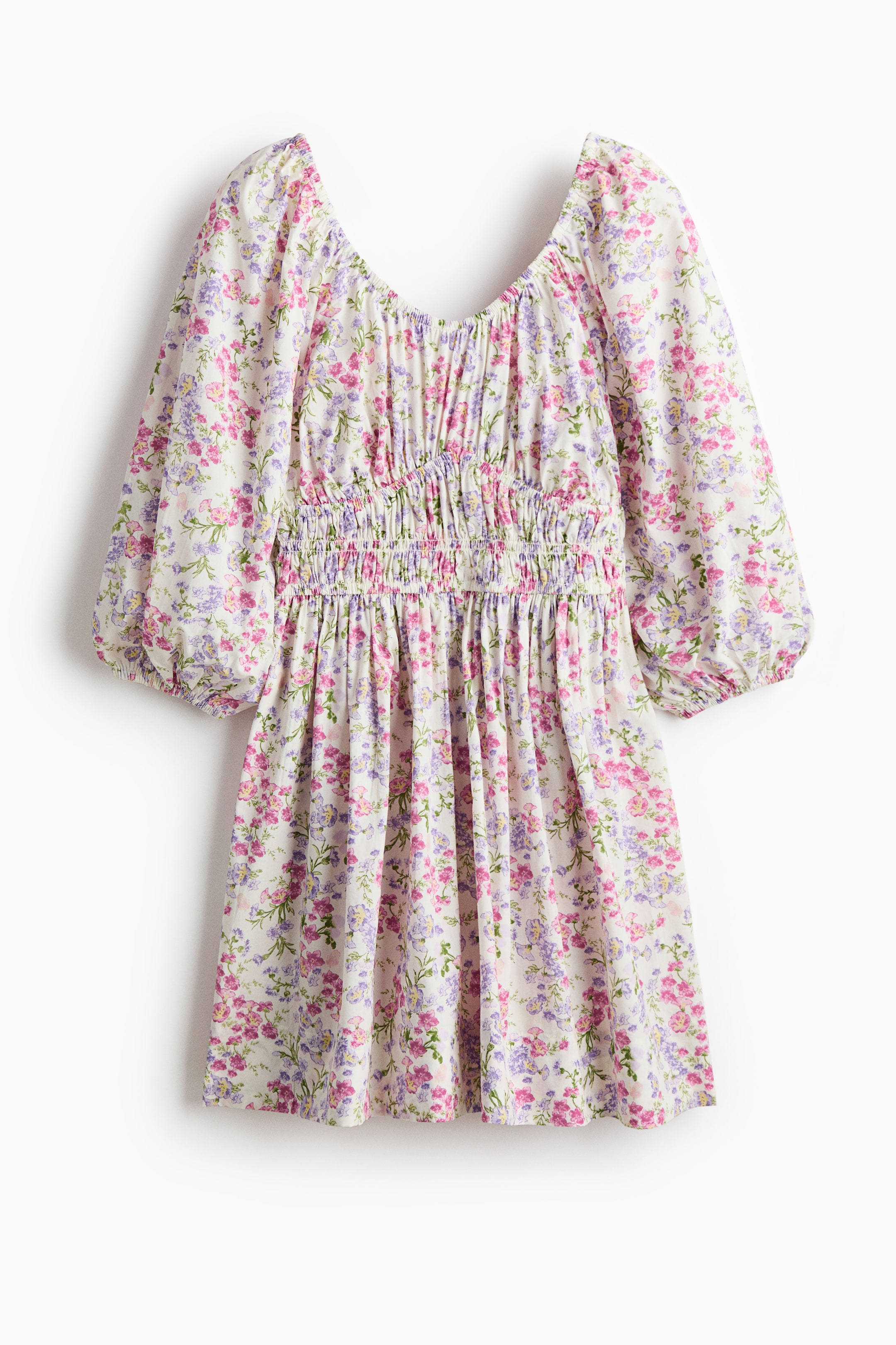 Xem ảnh lớn hơn: Một chiếc váy ngắn in hoa trên chất liệu cotton đang được trưng bày từ phía trước, có đường viền cổ hình chữ V co giãn và tay áo phồng dài tới khuỷu tay với đường viền hẹp ở cổ tay. Váy có phần thân ôm sát với phần eo được xếp ly và chân váy xòe.