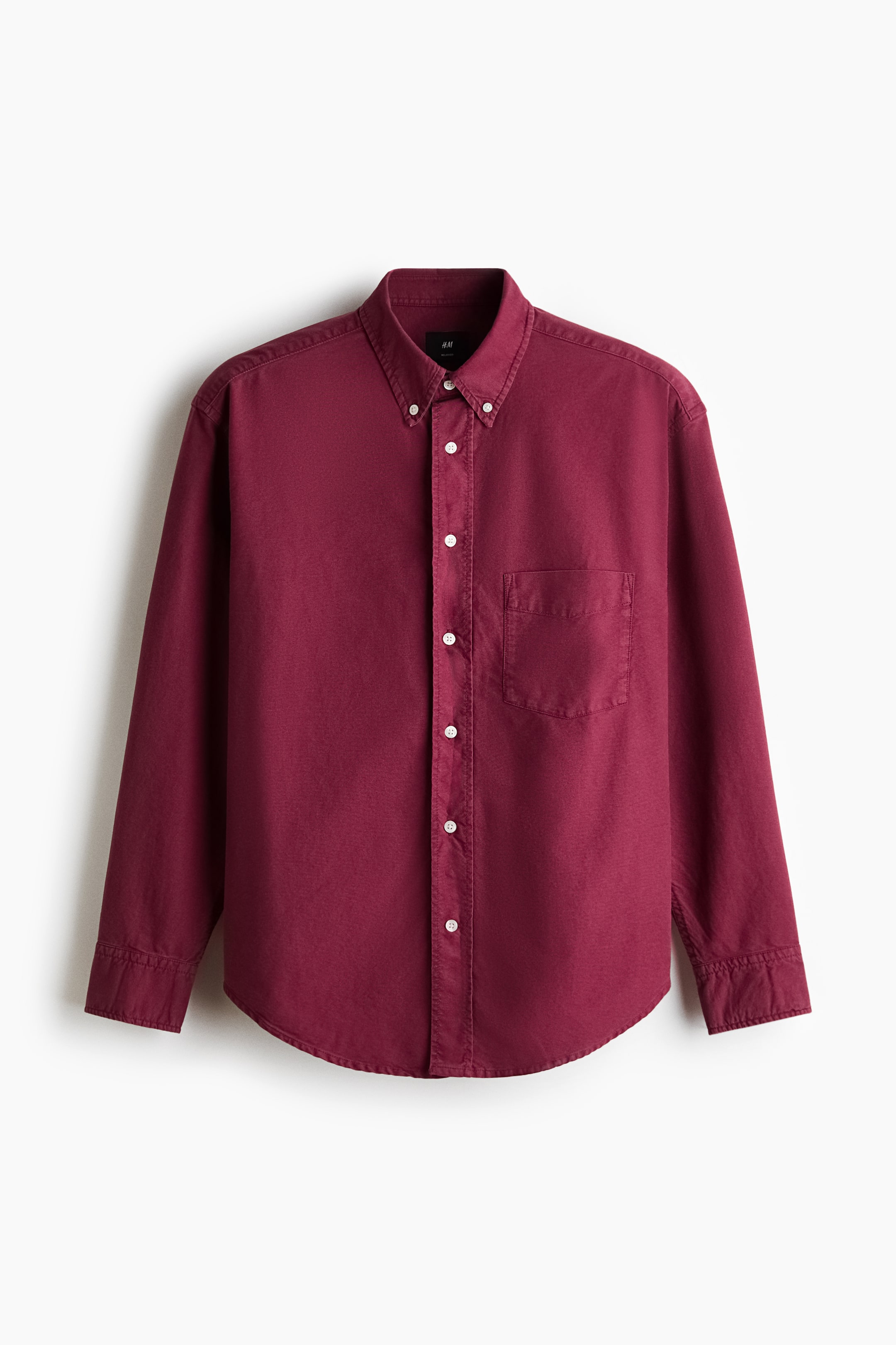 View larger image: Presenting a deep red Oxford shirt from the front view, it features a button-down collar and a classic front placket adorned with white buttons. The design showcases long sleeves with buttoned cuffs, an open chest pocket on the left side, and a gently rounded hem, offering a relaxed silhouette.