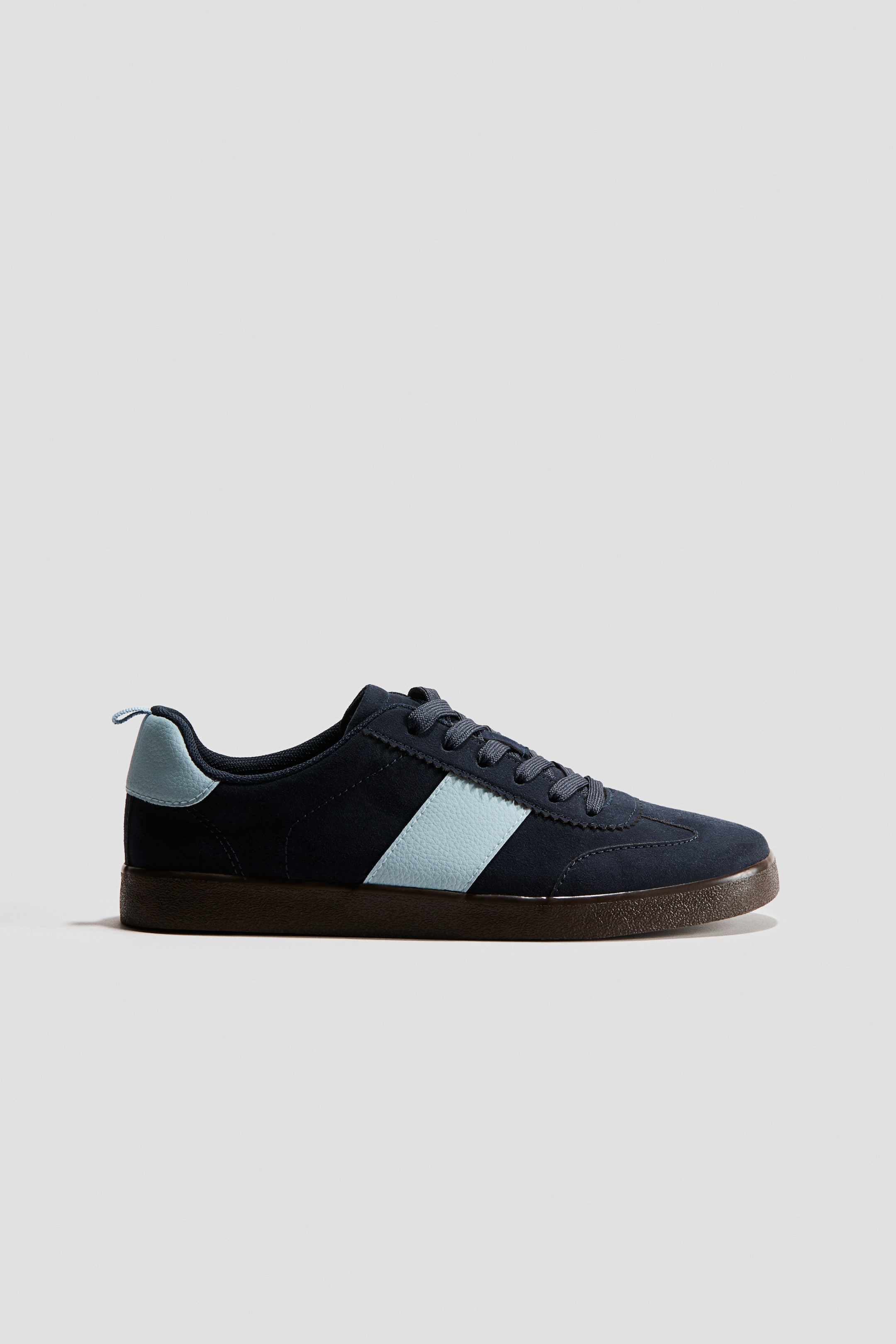 Agrandir l'image: Ces baskets présentent une tige en daim bleu foncé avec une bande texturée bleu clair sur le côté et une patte de talon assortie. Des lacets bleu foncé assurent le maintien à l'avant, et une semelle brun foncé forme la base.