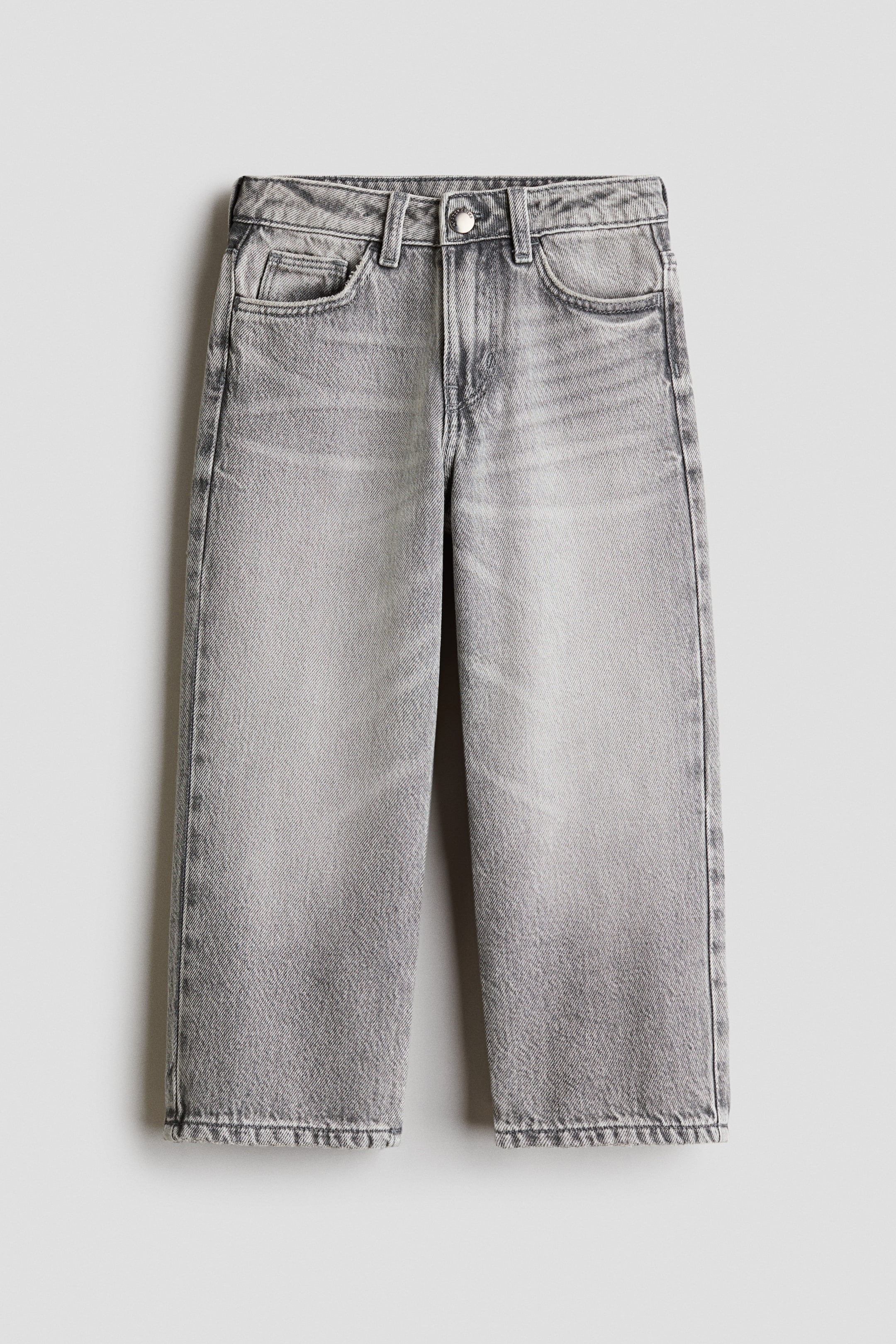 Größeres Bild anzeigen: Jeans präsentieren eine Vorderansicht, flach liegend. Sie sind in einer hellgrauen, verwaschenen Optik mit weitem Bein und im Fünf-Taschen-Stil gestaltet. Die Jeans verfügen über einen Knopfverschluss, Gürtelschlaufen und gesäumte Säume mit einer sichtbaren, leicht ausgefransten Kante.