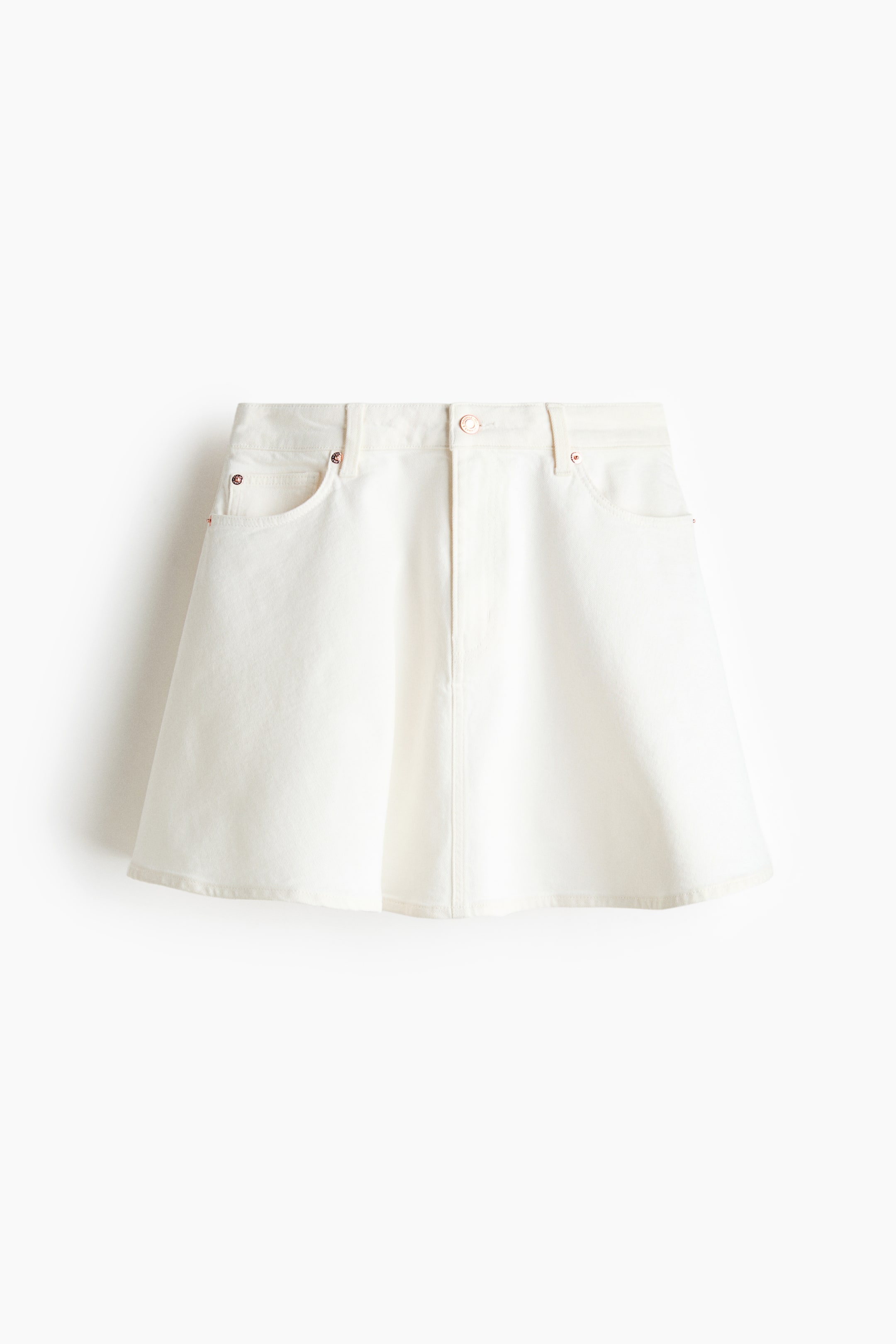 View larger image: A short white denim skirt is showcasing its front view. It features a flared silhouette, a waistband with belt loops, a front button and zip fly closure, and two front pockets adorned with rose gold-toned rivets.