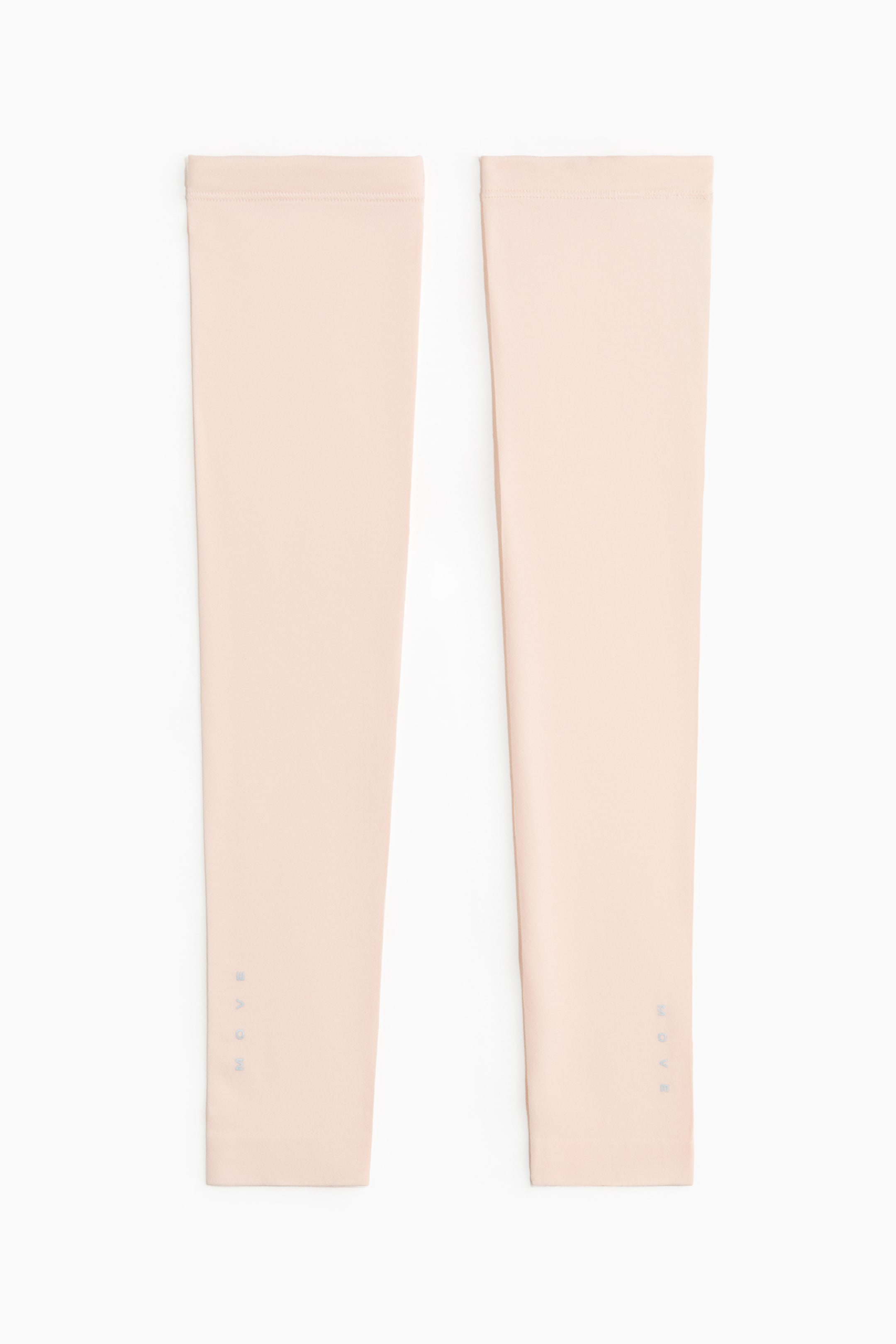 Näytä suurempi kuva: Vaalean persikanväriset juoksuhihat makaavat litteänä, esittäen etupuoltaan. Niissä on toiminnallinen kangas, joustavat silikonireunukset ylhäällä ja alhaalla, sekä pystysuorat "MOVE"-heijastinyksityiskohdat lähellä hihansuita.