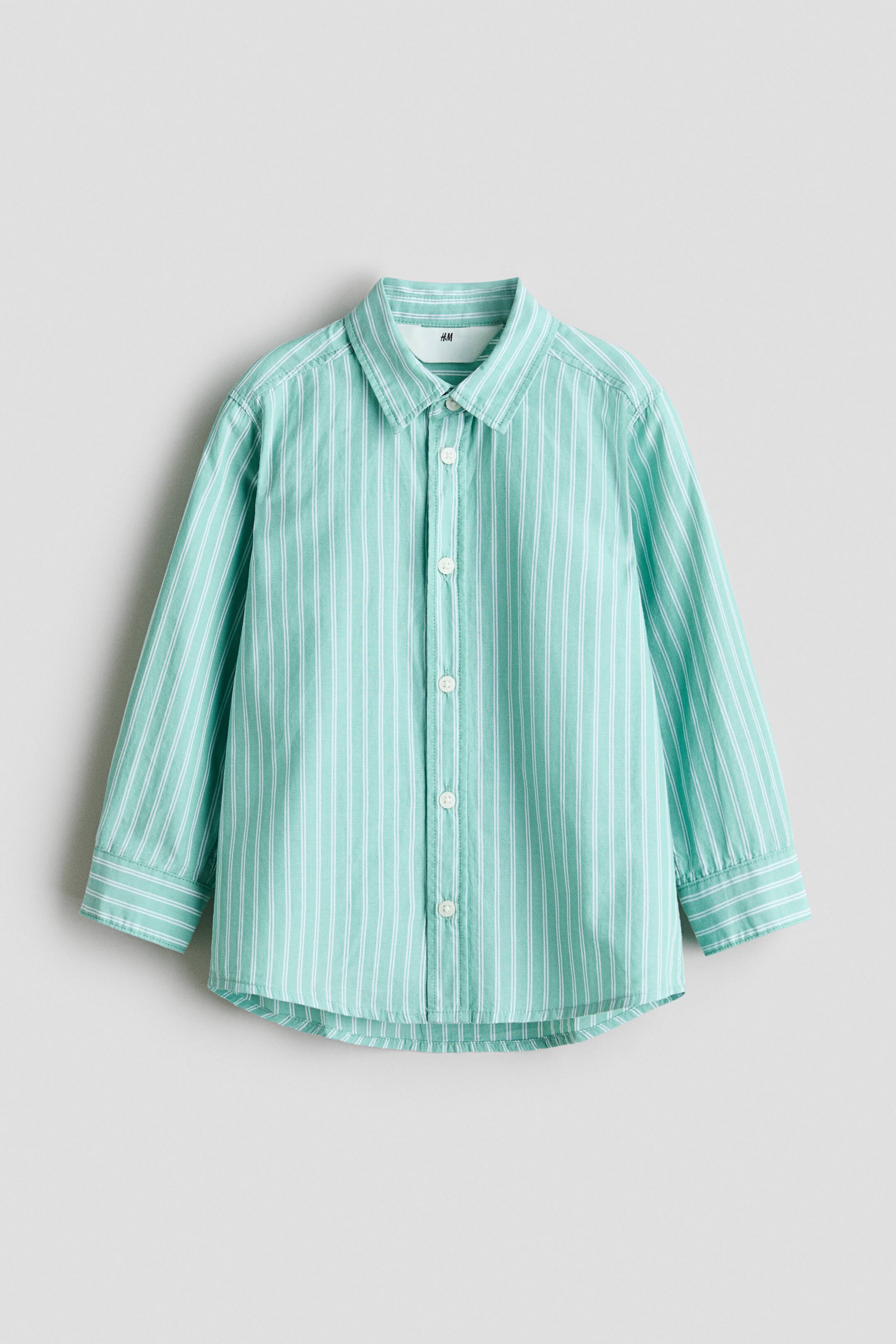 查看大圖: 綠白條紋襯衫的正面可以看到透氣的棉織紋、有翻領以及正面排扣。襯衫具有長袖，袖口有鈕扣，並且有稍長的圓弧形襯衣下擺。
