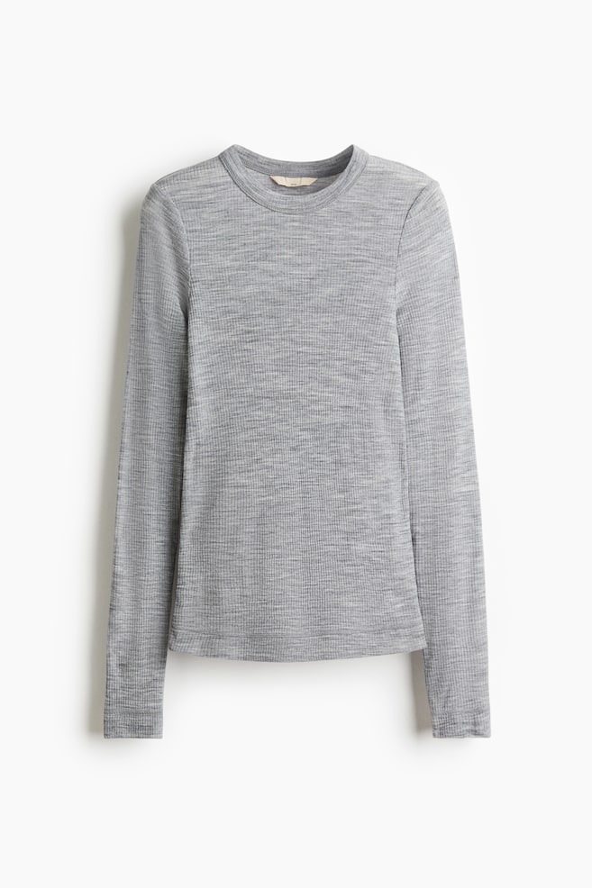 A fitted, long-sleeved top is being displayed front-facing, made from a sheer, heather grey rib-knit fabric and featuring a round, rib-trimmed neckline, long sleeves, and visible flatlock seams. - 1