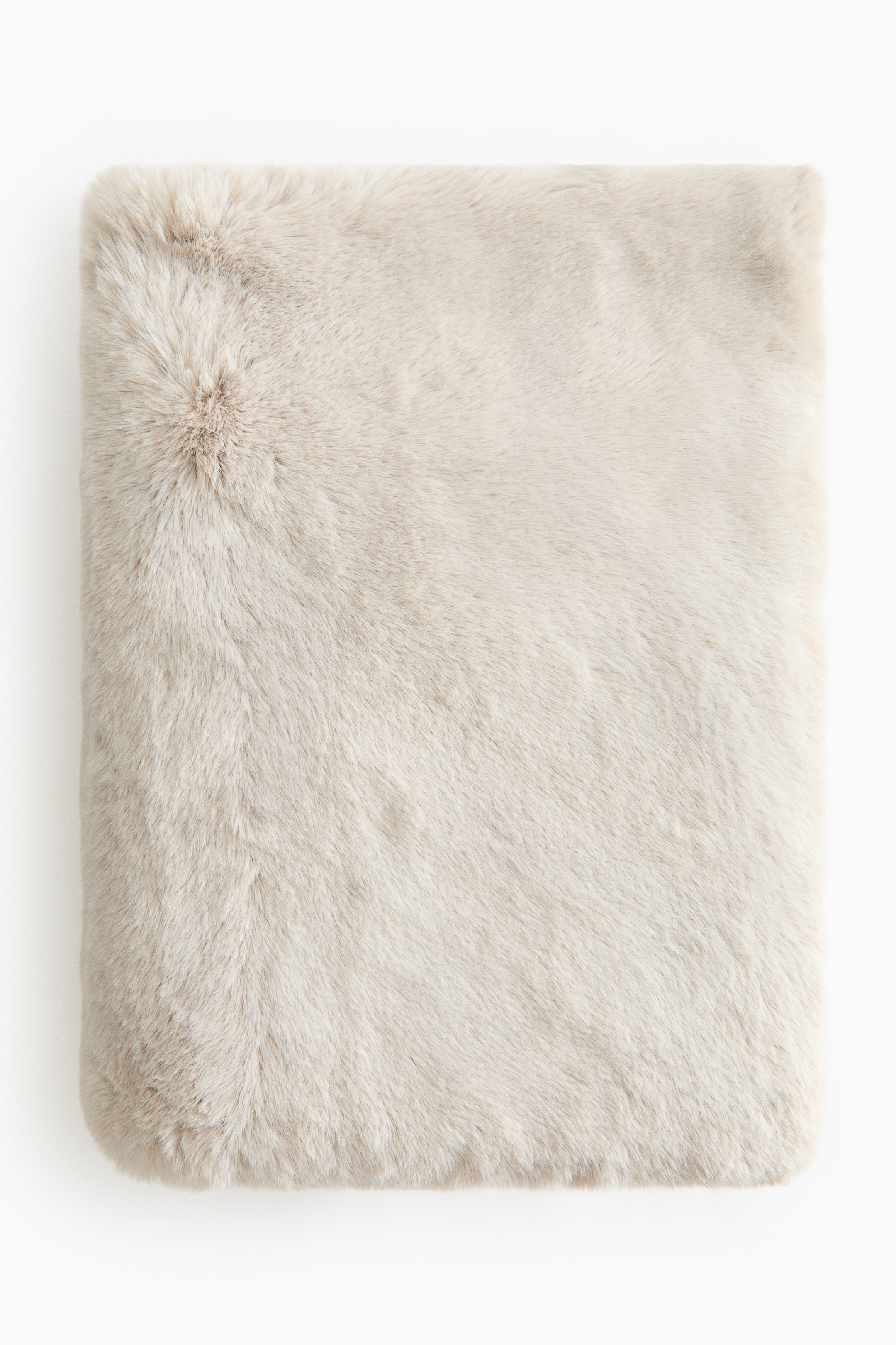 Agrandir l'image: La couverture moelleuse présente une texture en fausse fourrure pelucheuse beige clair. Elle est posée à plat, montrant sa face avant.
