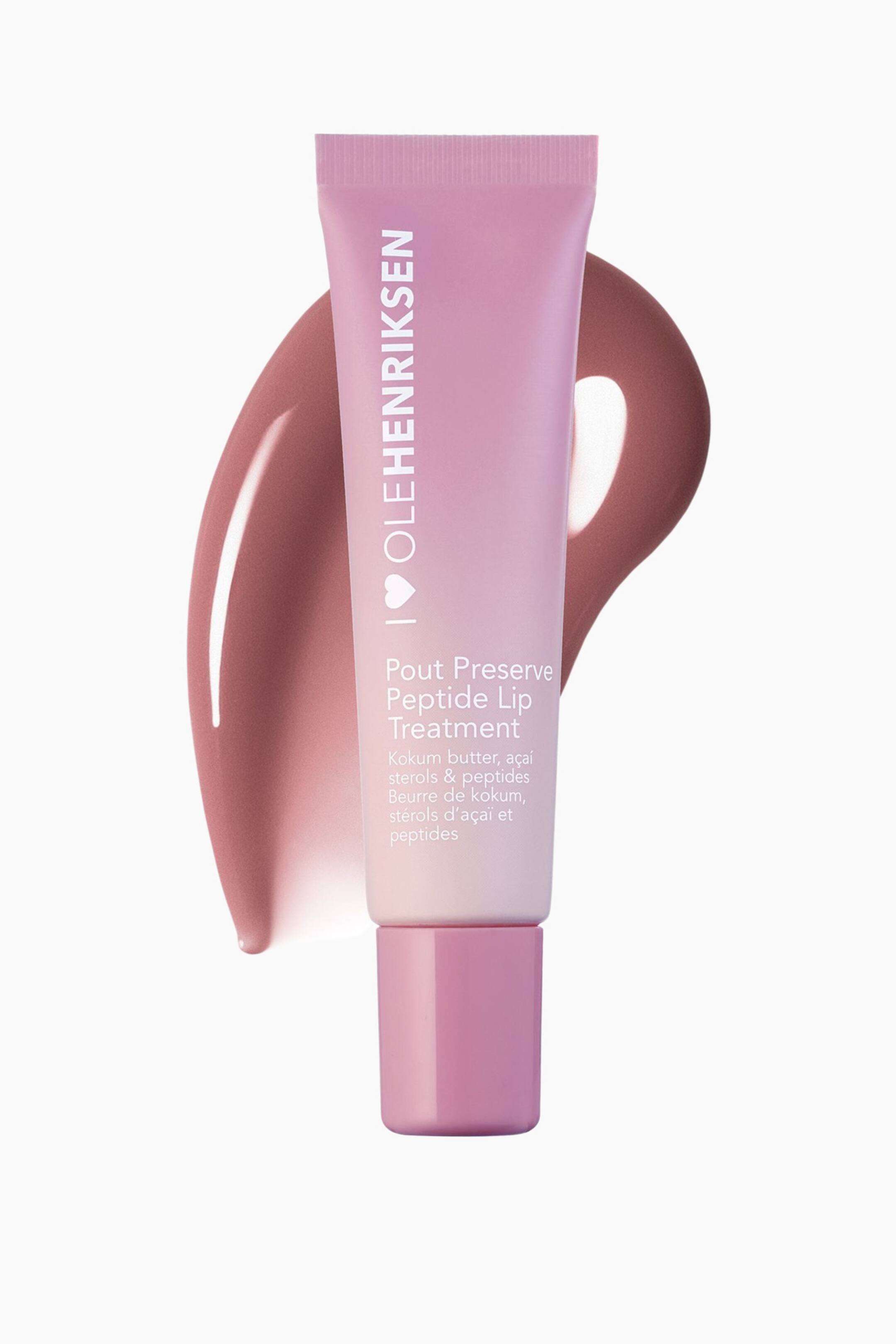 Visa större bild: Ett Olehenriksen Pout Preserve Peptide Lip Treatment-rör, med en rosa och lila gradient, står upprätt och är något vinklat åt höger. En glansig, rosbrun färgprov av produktens nyans syns bakom röret, böjd från övre vänstra hörnet till nedre högra hörnet.