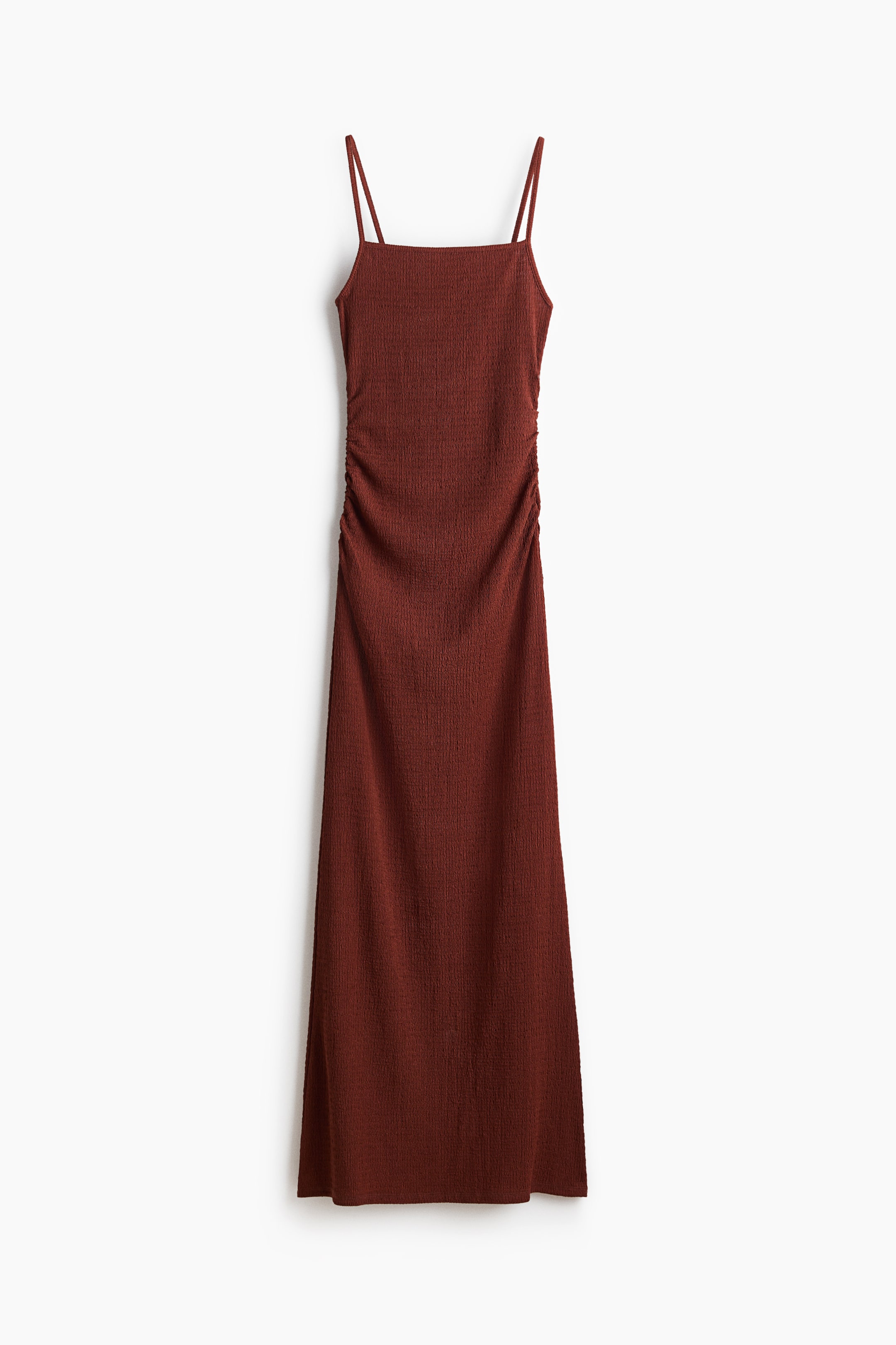 Xem ảnh lớn hơn: Chiếc maxi slip dress màu nâu đỏ sẫm được trình bày ở góc nhìn chính diện, có cổ vuông, dây mảnh kiểu spaghetti và nếp nhún dọc hai bên thân. Váy được làm từ chất liệu có kết cấu.