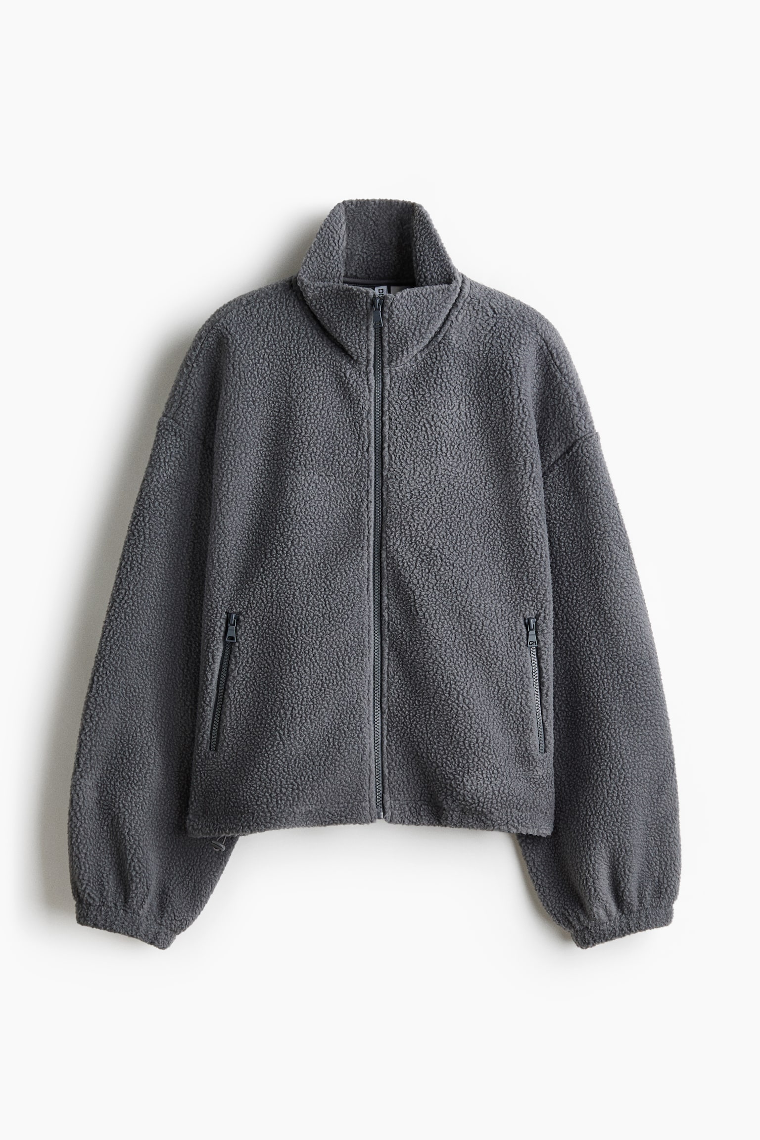 A dark grey teddy fleece jacket is shown from the front, featuring a full-length zip closure and a stand collar. It has two zippered pockets on the front, with long sleeves finished with elasticated cuffs. - 1