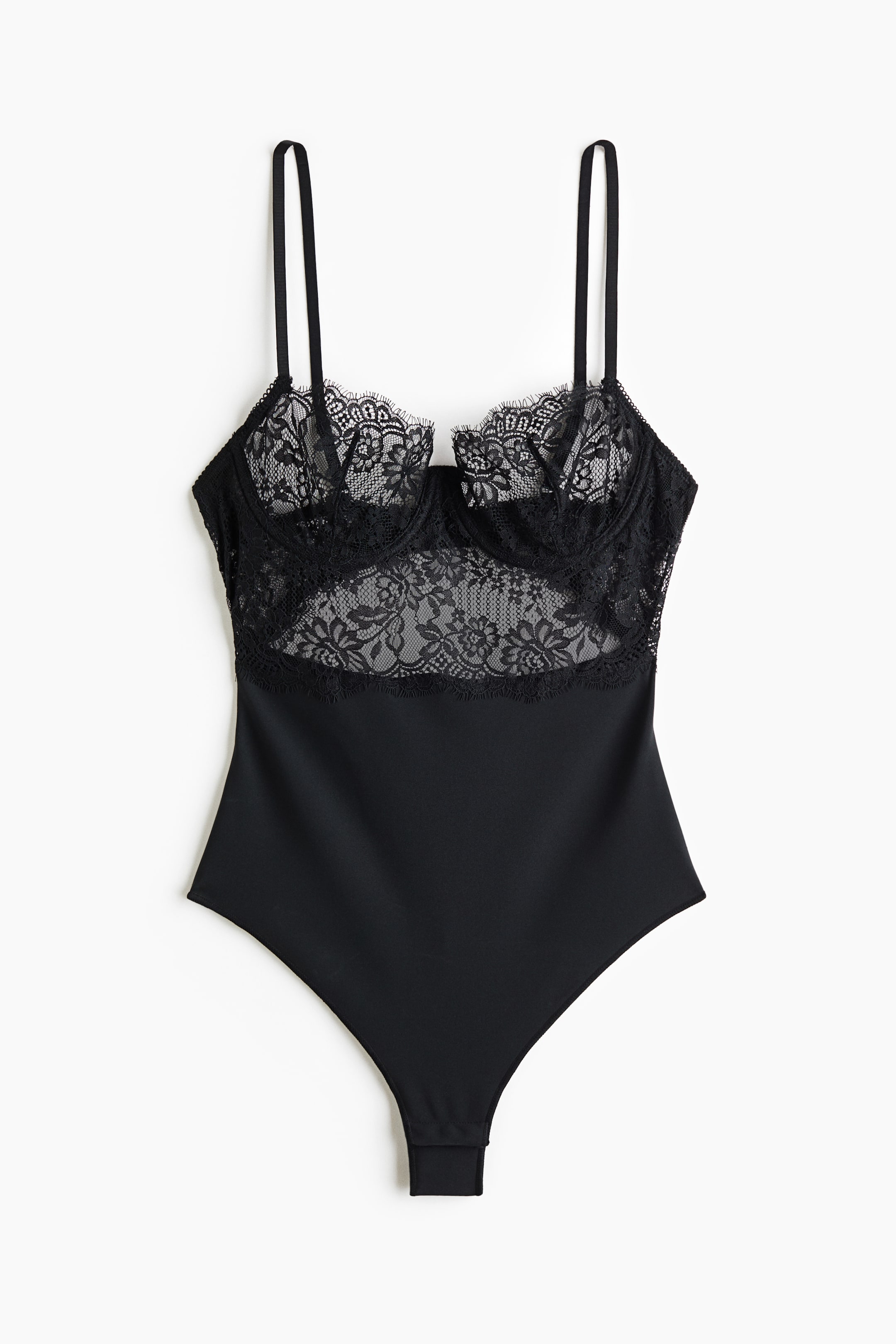 View larger image: A black bodysuit is facing front, featuring underwired cups and a midriff panel made of sheer floral lace with delicate eyelash trim. The lower body is displaying a solid, opaque fabric with a high-cut leg, while thin, adjustable shoulder straps are extending from the top.