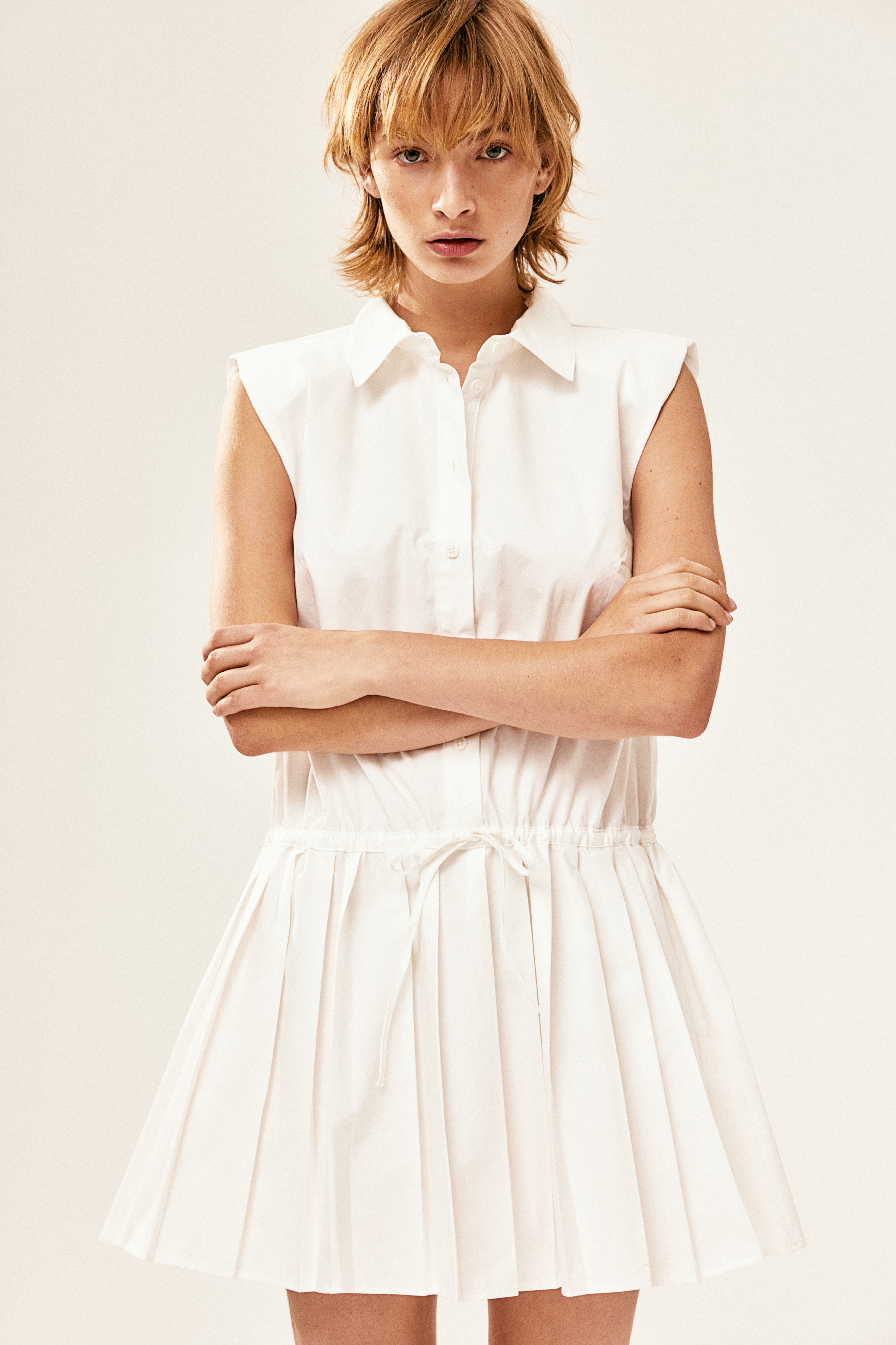 shoulder-pad dress with pleated skirt